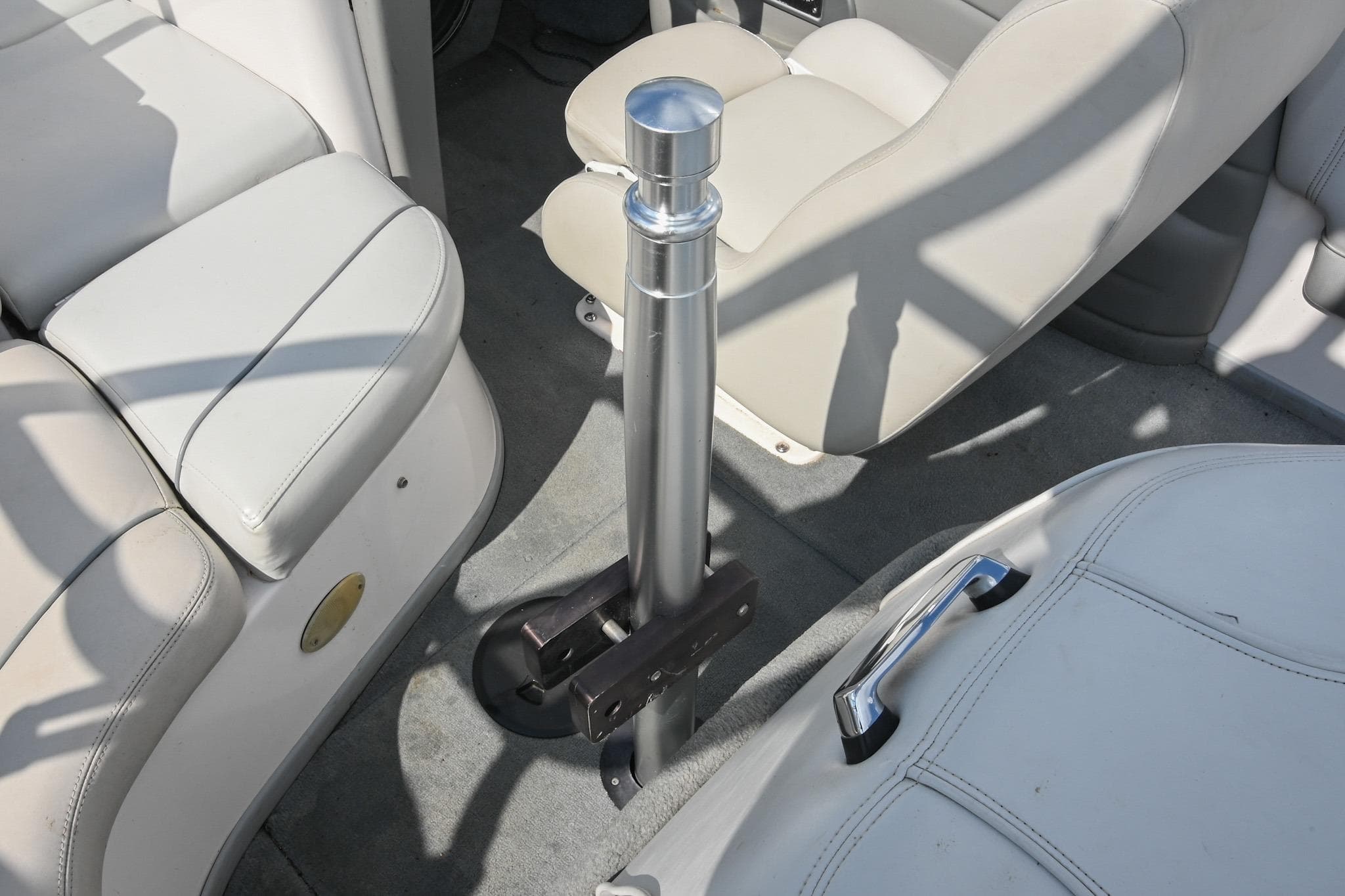 Interior of a 2004 Supra Launch SS boat with beige seating and a central metal pole.