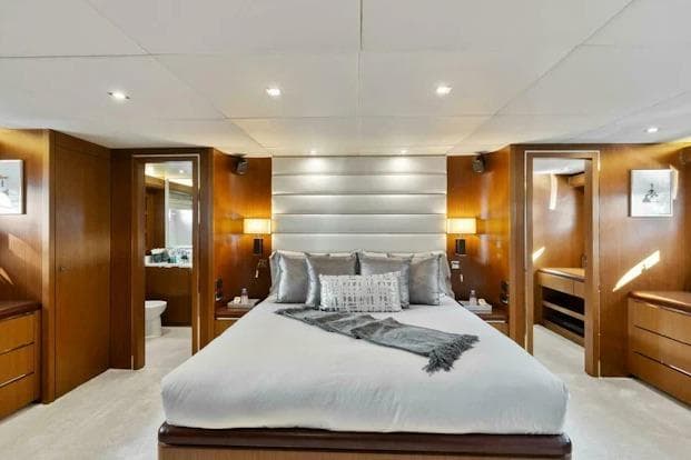 Luxurious bedroom interior on 2006 Tecnomar 35 Nadara yacht, featuring elegant wood finishes.