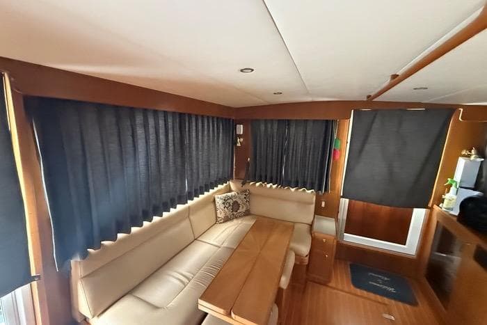 Interior of 2007 Island Pilot 395 yacht with beige seating and wooden table.