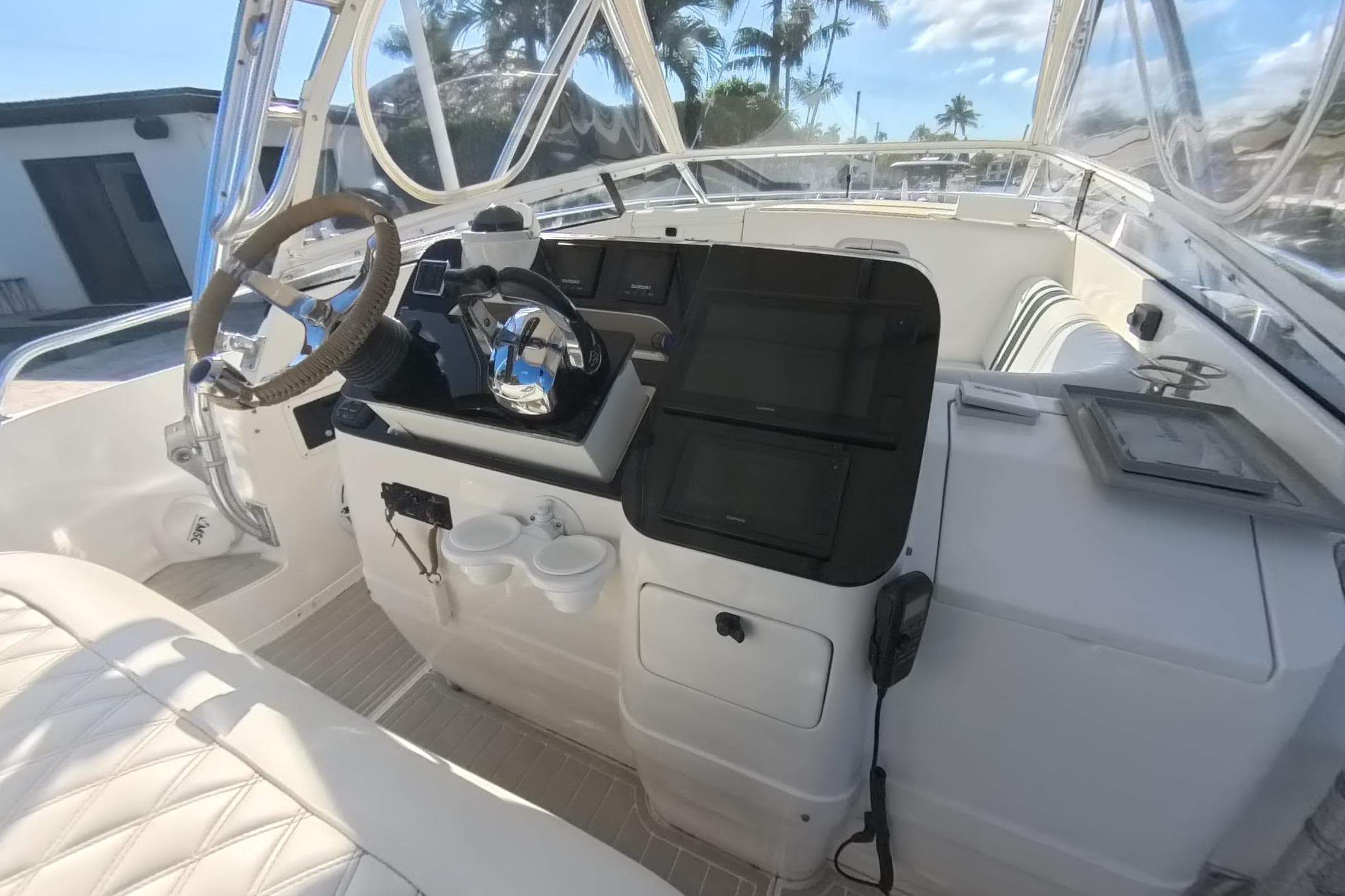 2005 Intrepid 348 Walkaround helm with steering wheel, controls, and navigation screens.