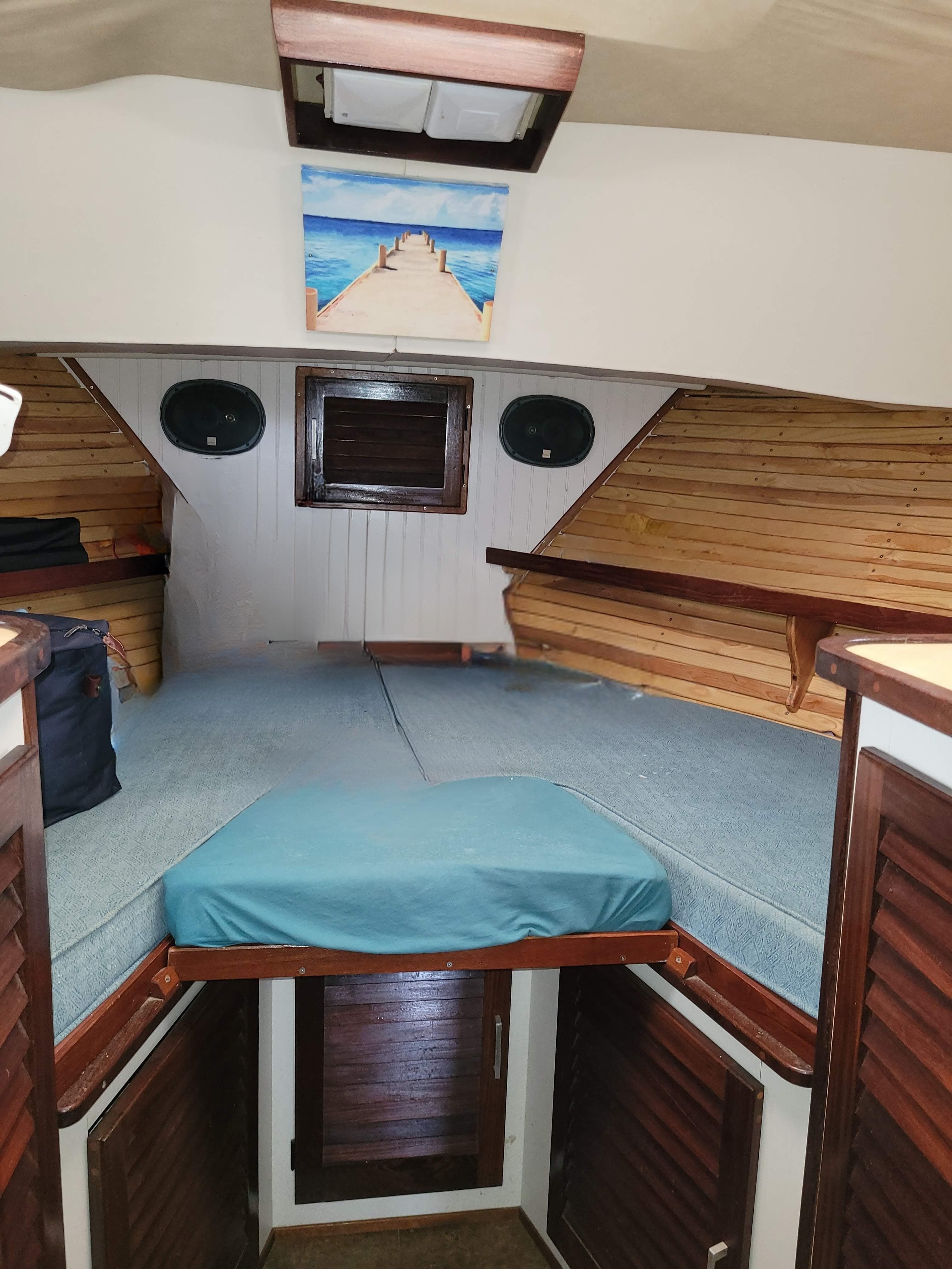 1981 Mainship 34 Trawler cabin interior with wood paneling and cozy sleeping area.