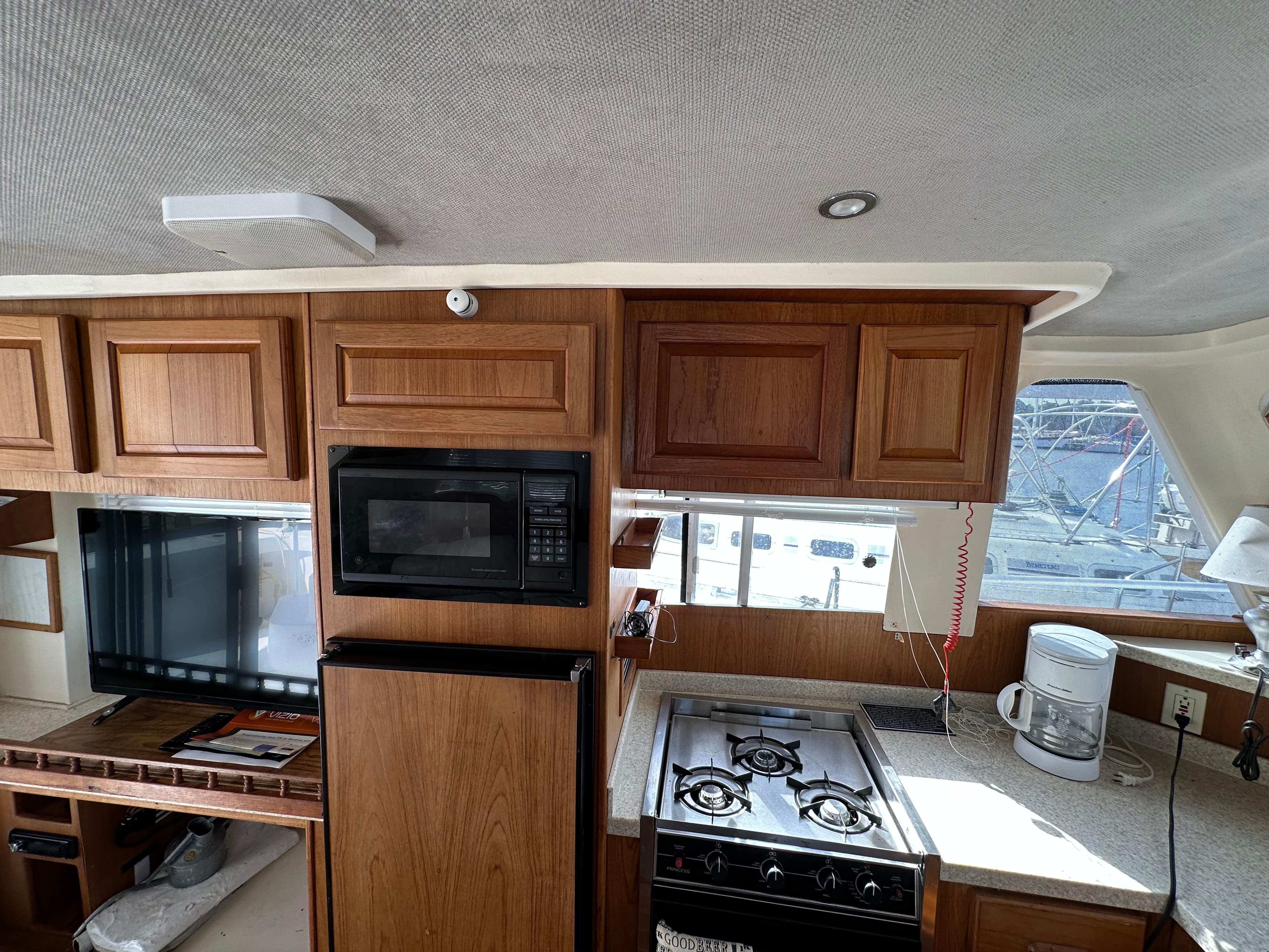 Interior of 1998 Mainship 350 Trawler with kitchen appliances and wooden cabinetry.
