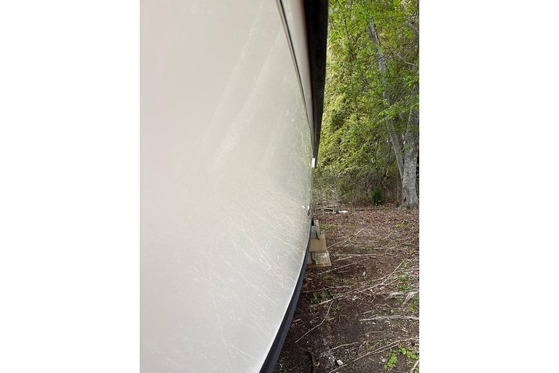Side view of a 2008 Parker 2510 XL Walkaround boat on land.