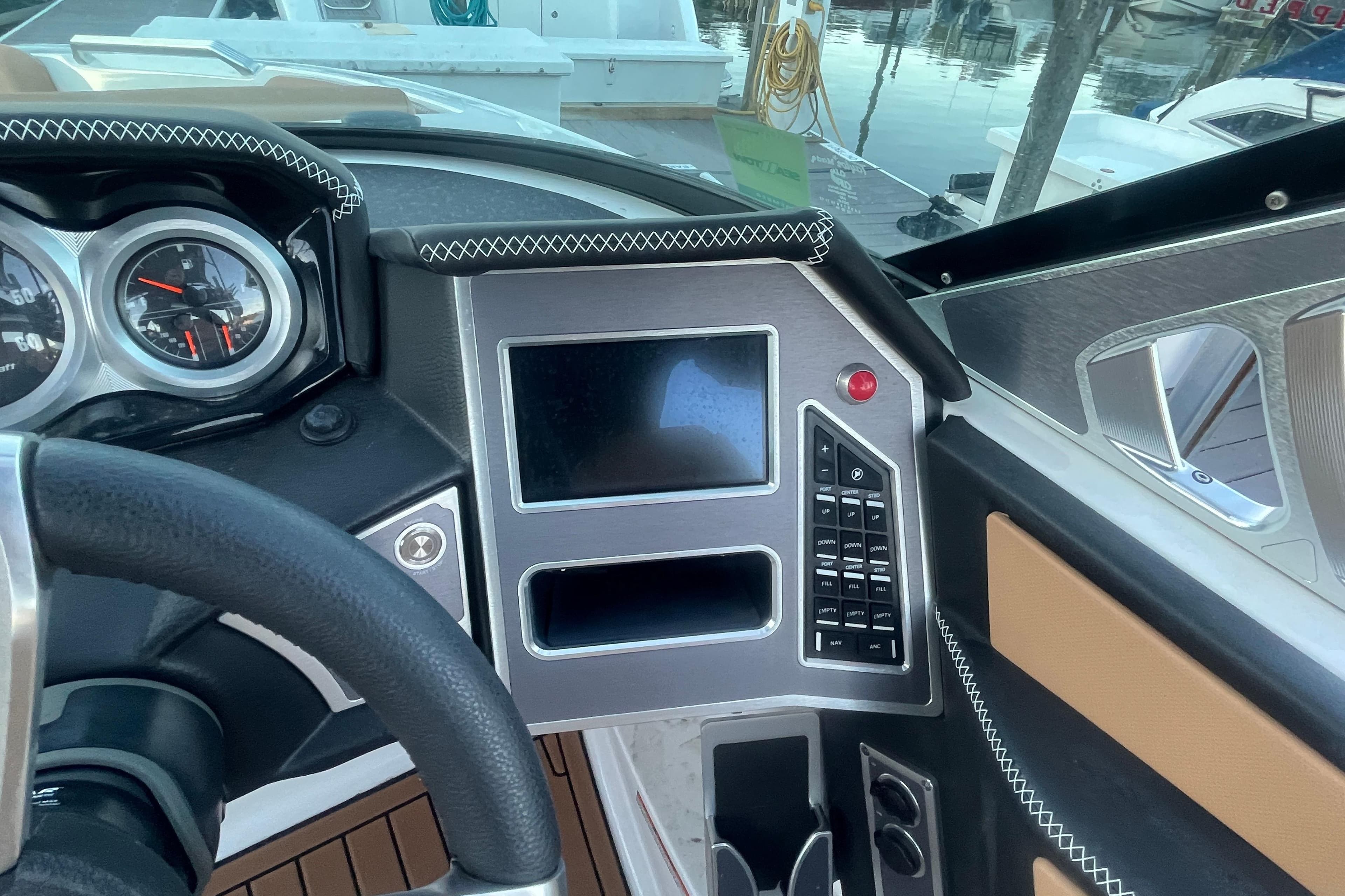 2021 MasterCraft XT21 dashboard with modern controls and sleek design at a marina.