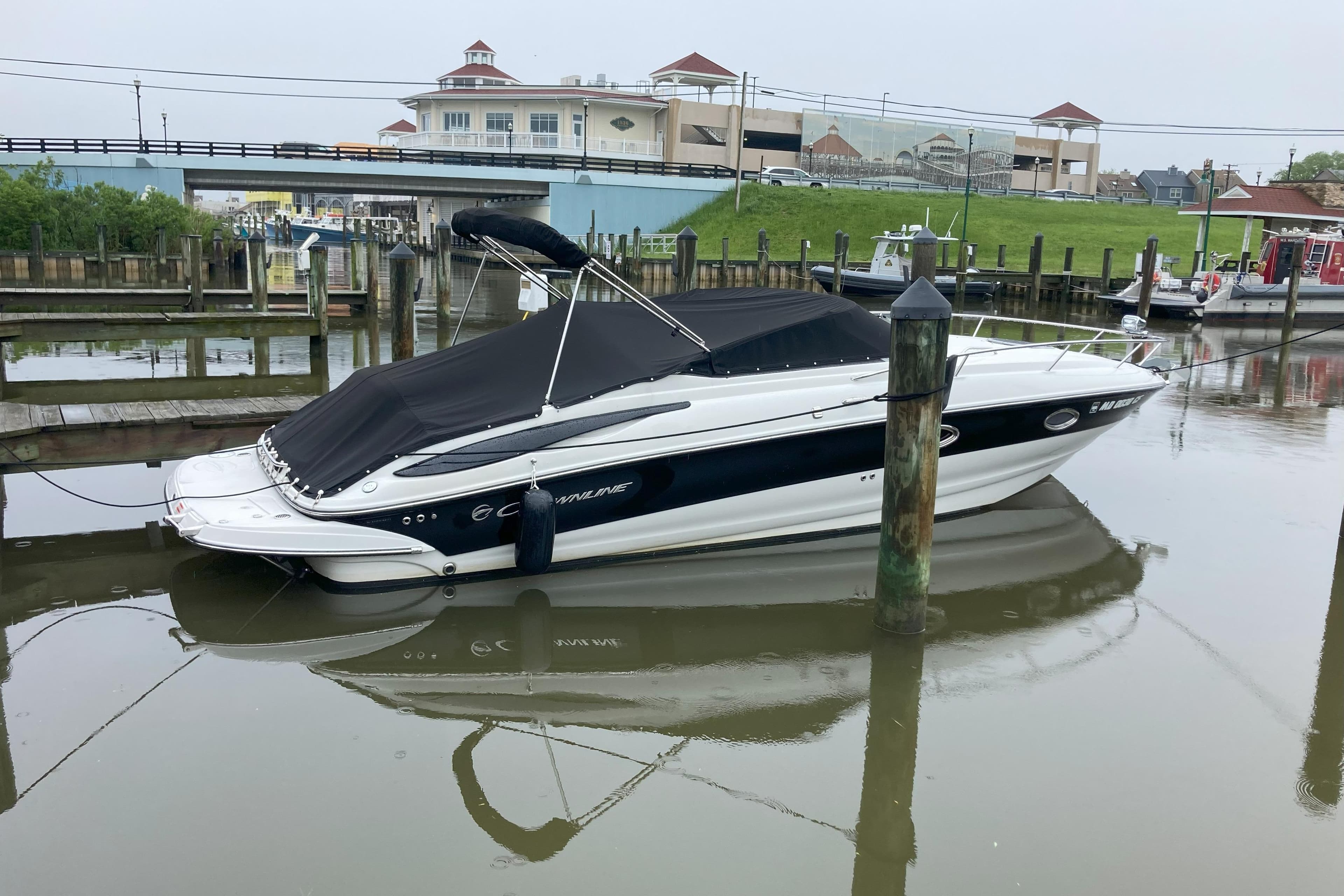 2011 Crownline 286 SC boat docked in a marina with a black cover.