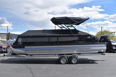 2026 Princecraft Quorum 25 RL pontoon boat with black canopy on trailer.