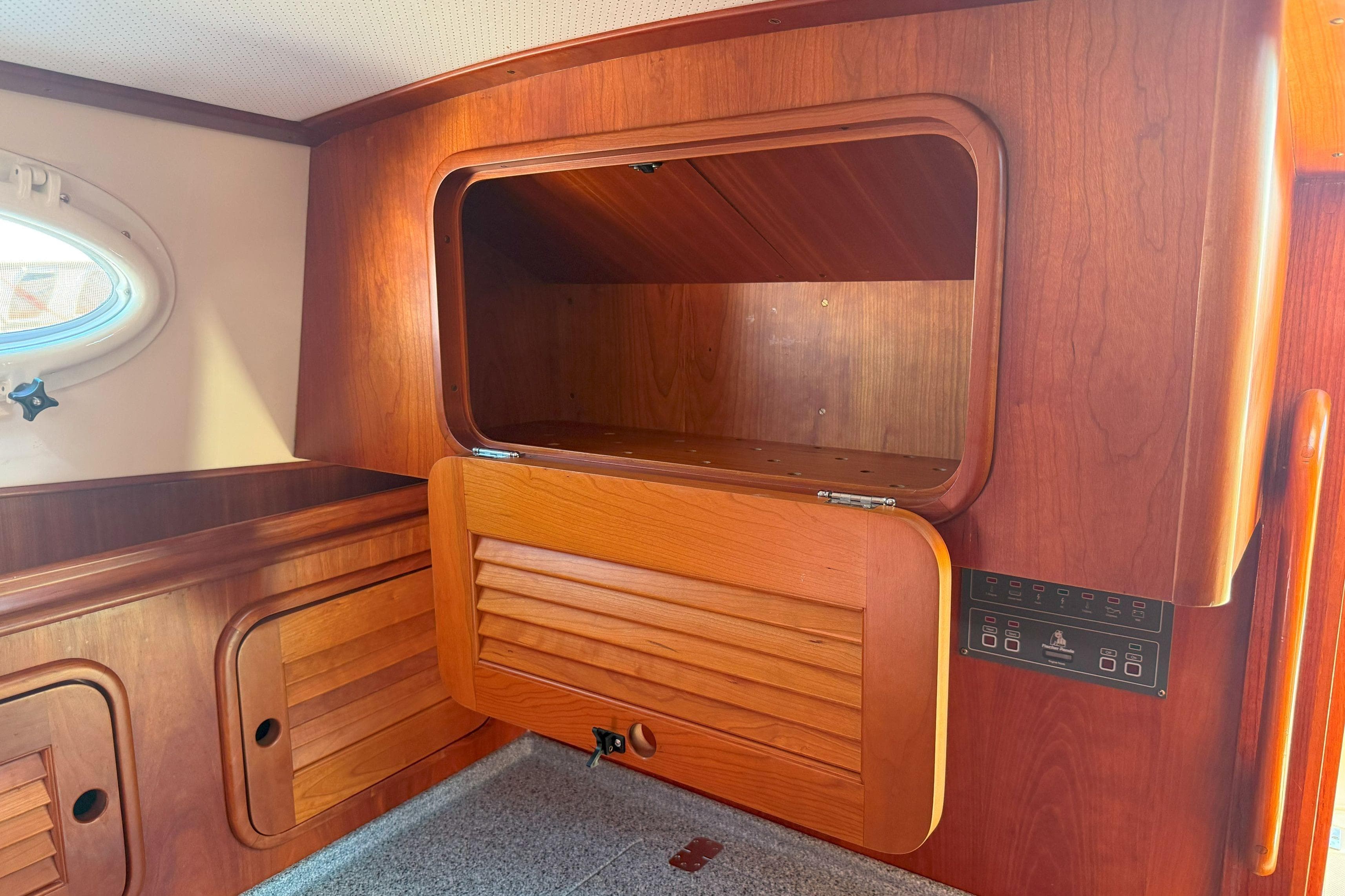 2003 Hinckley Talaria 40 interior with wooden cabinetry and open storage compartment.