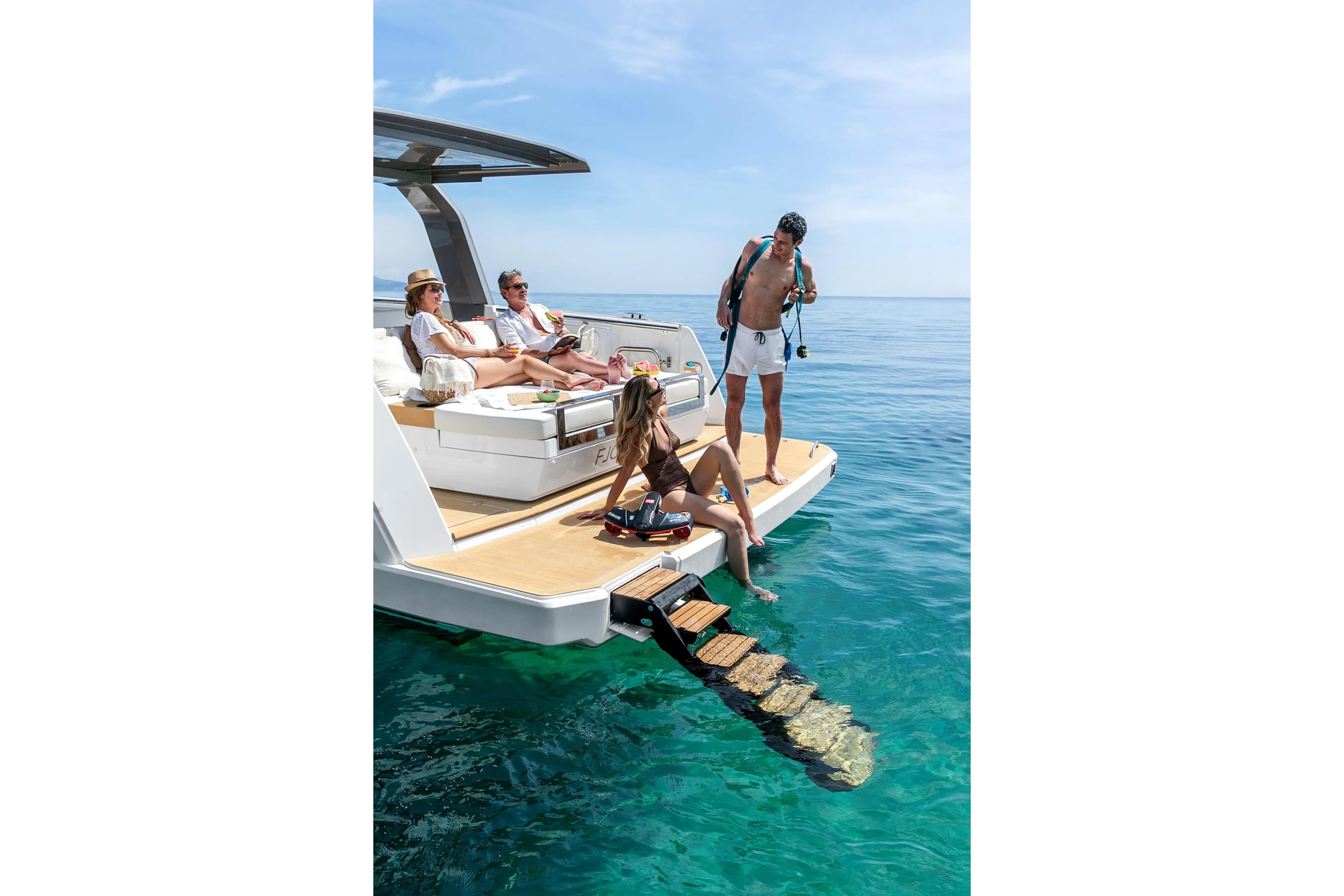 People relaxing on a 2025 Hanse Fjord 39 XL yacht in clear blue water.