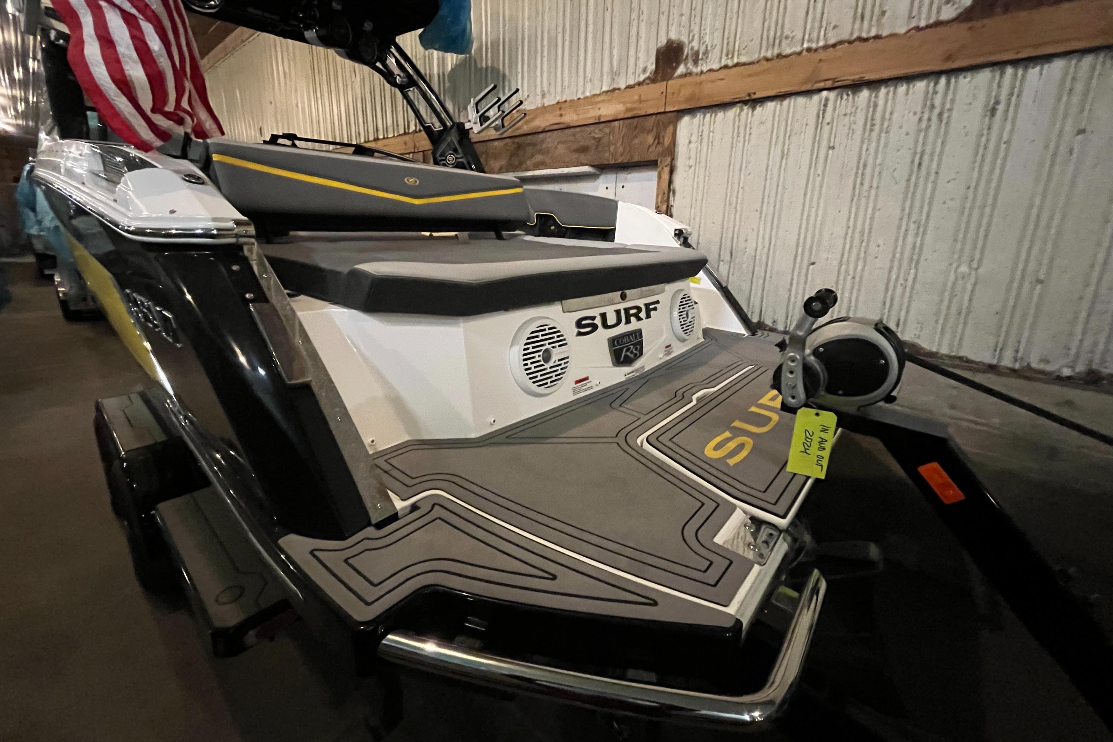 2021 Cobalt R8 Surf boat in a warehouse, featuring sleek design and surf accessories.