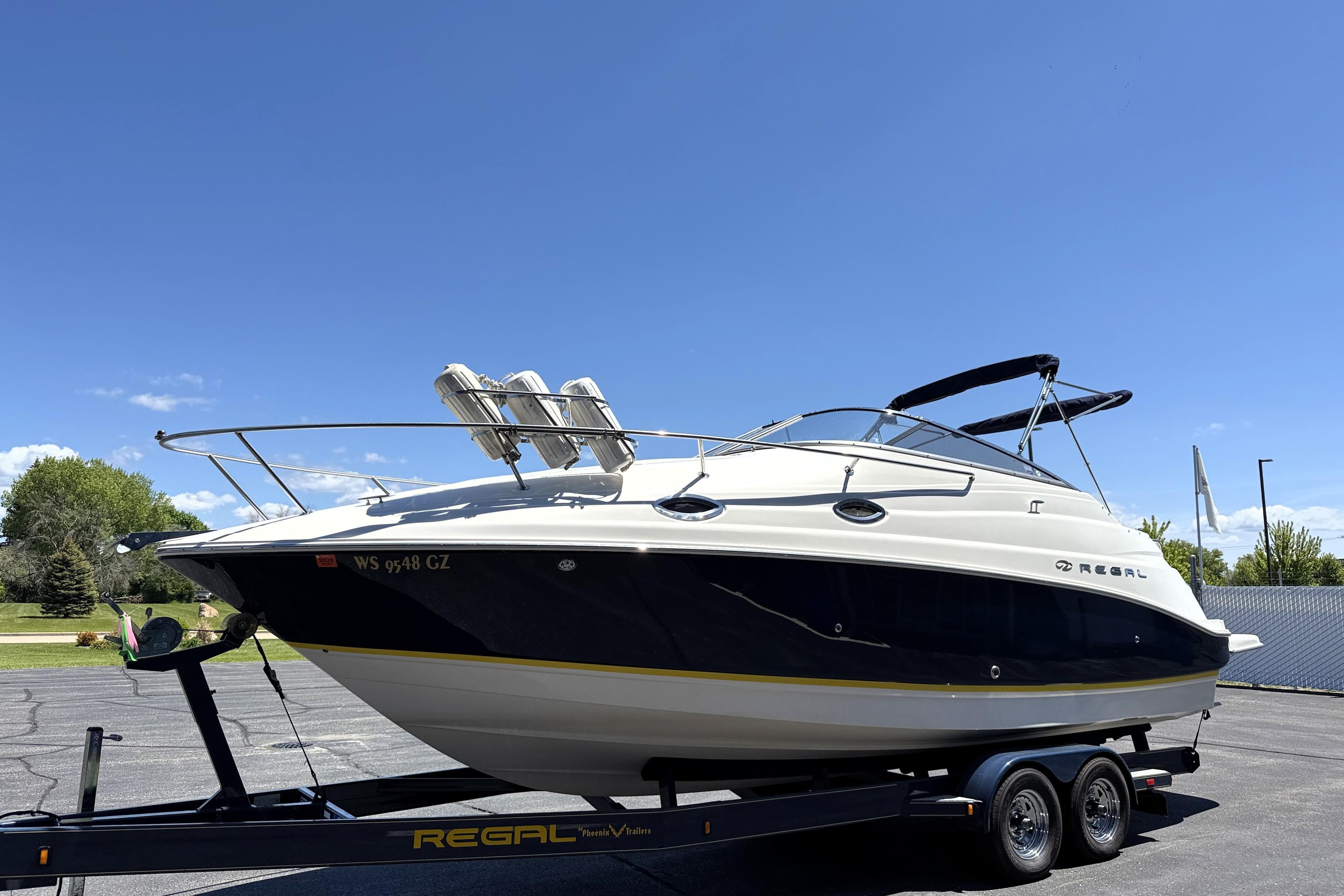 2005 Regal Commodore 2665 boat on trailer under clear blue sky.