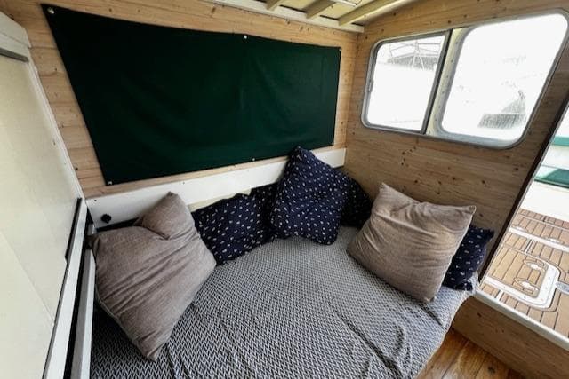 Cozy interior of 1978 Bruno & Stillman Custom Cruiser with cushions and wooden paneling.