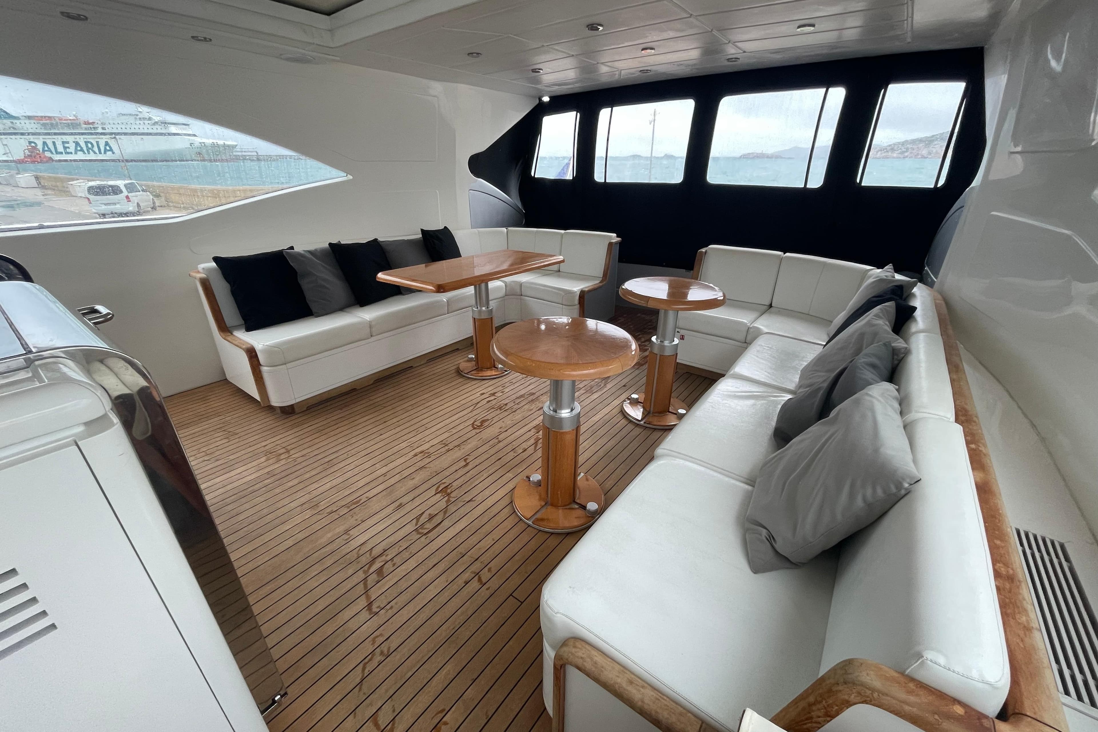Luxurious 1999 Mangusta 72 yacht interior with elegant seating and wooden flooring.