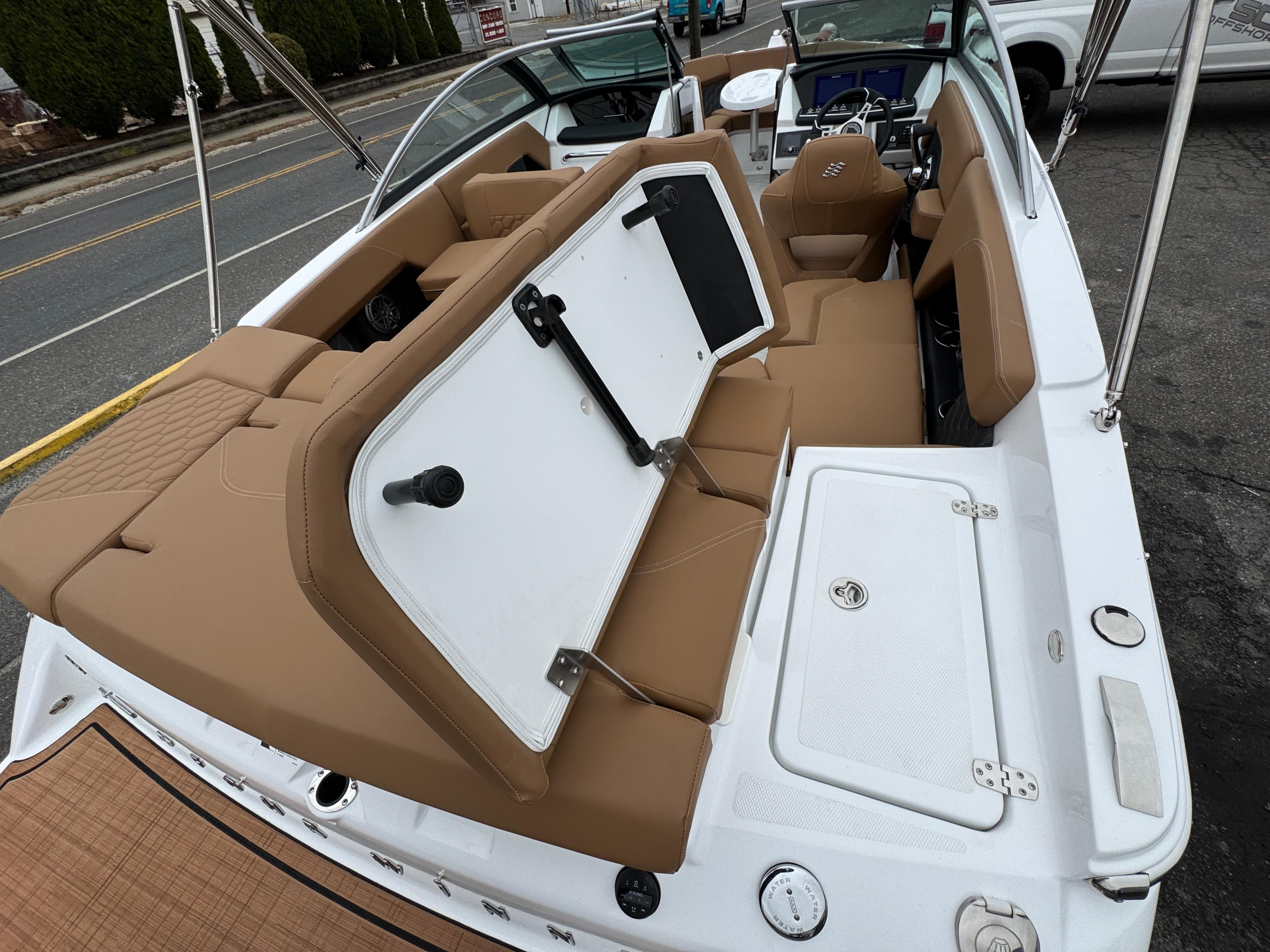 2025 Four Winns H2 OB boat interior with tan seating and storage compartments.
