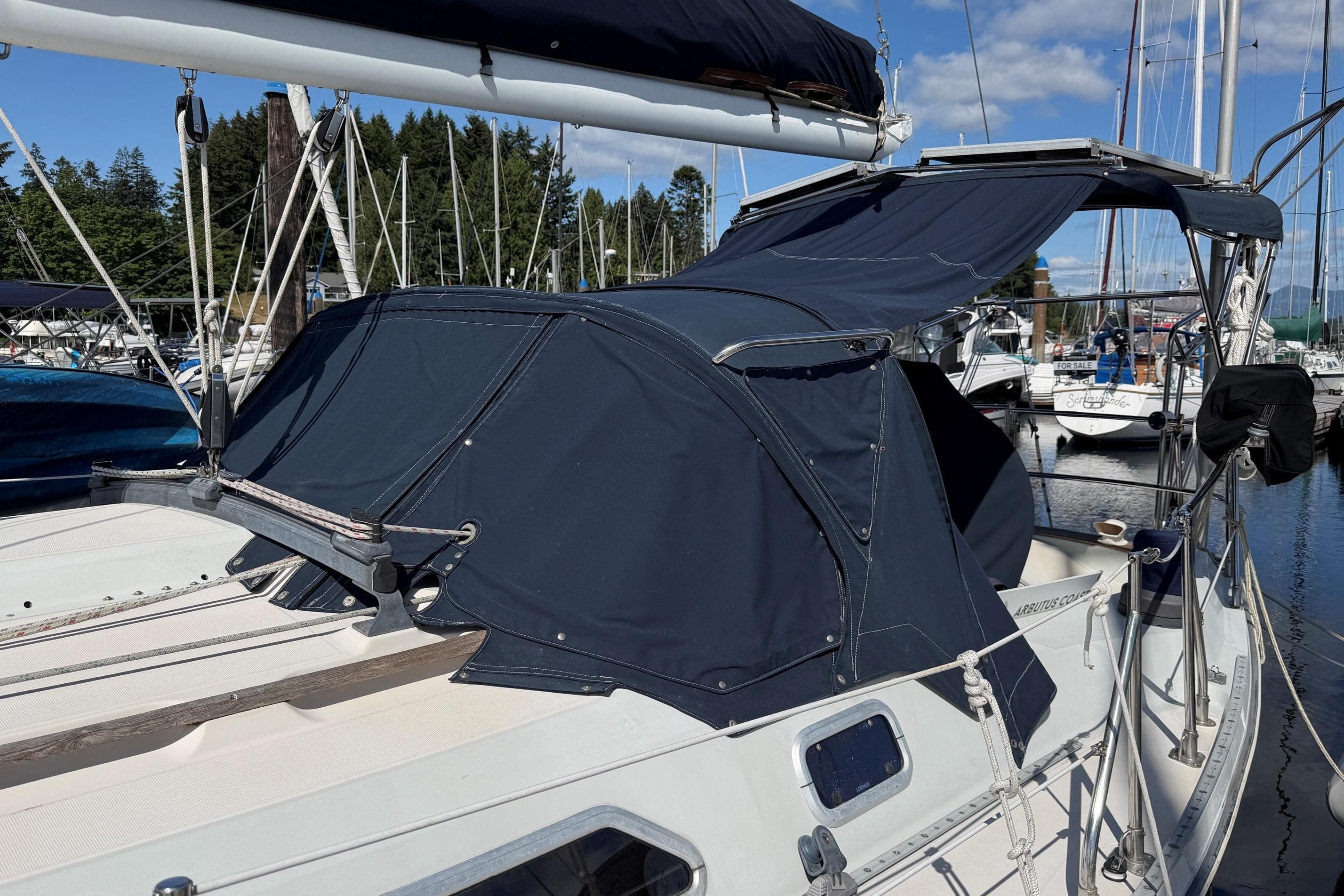 1989 Ericson 38-200 Masthead Sloop with navy canvas cover docked at marina.