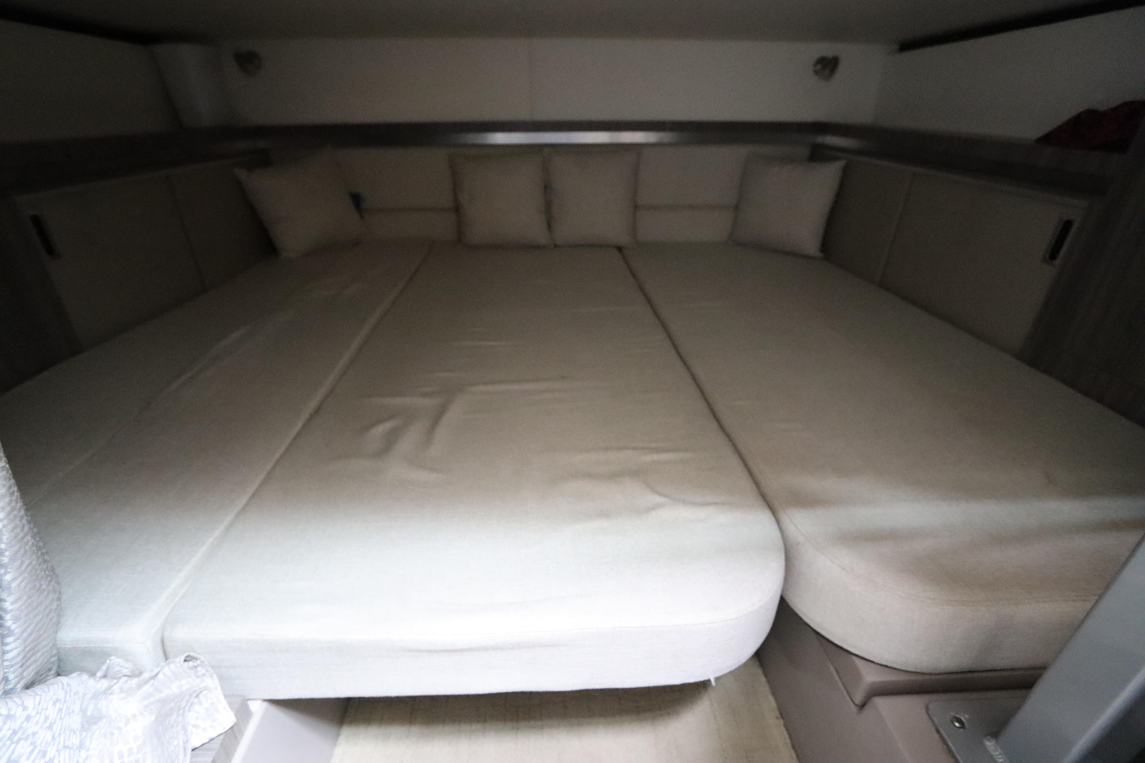 Interior cabin of 2019 Sea Ray Sundancer 320 with beige cushions and bedding.