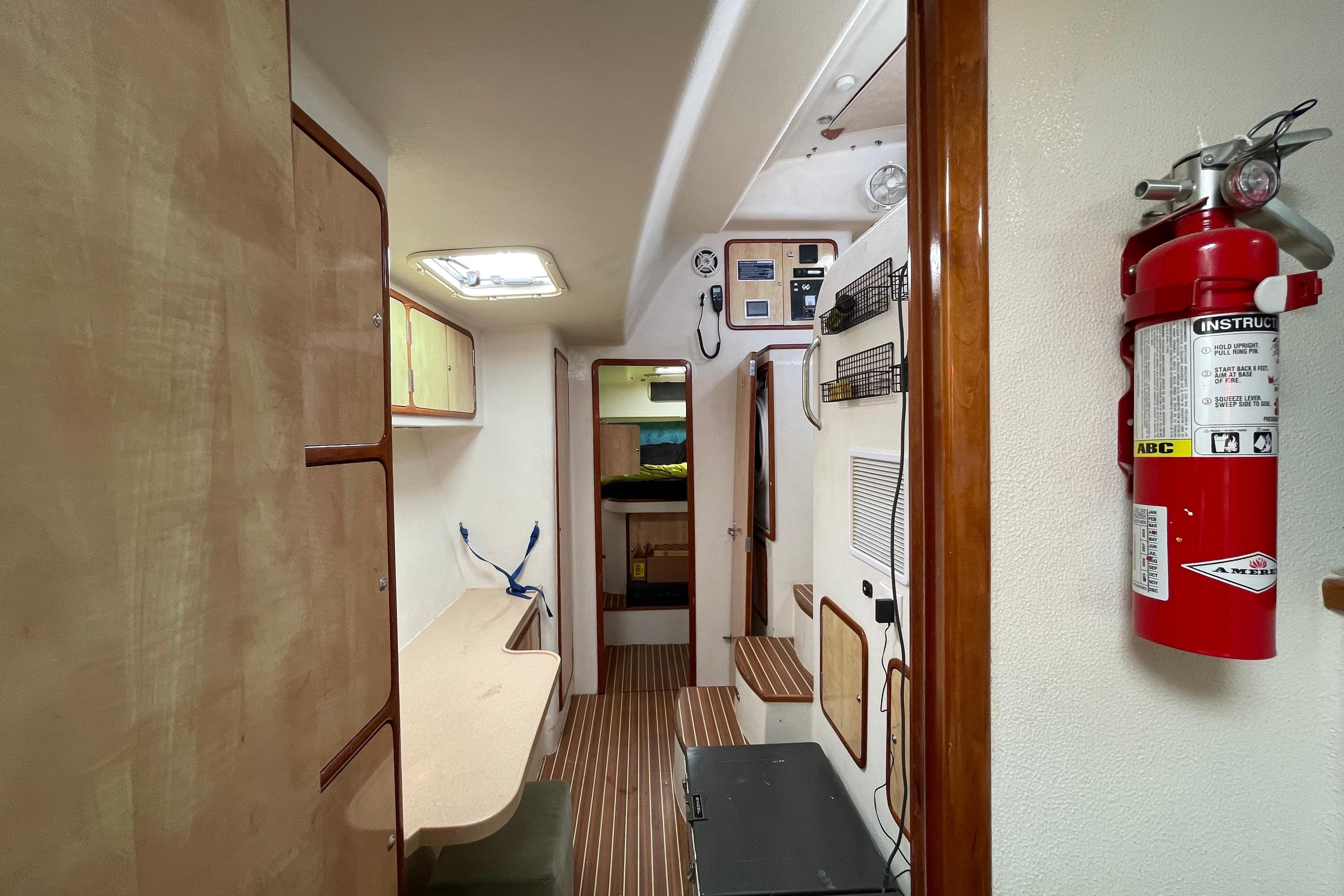 Interior of 2010 Knysna 480 yacht with wooden cabinetry and fire extinguisher.