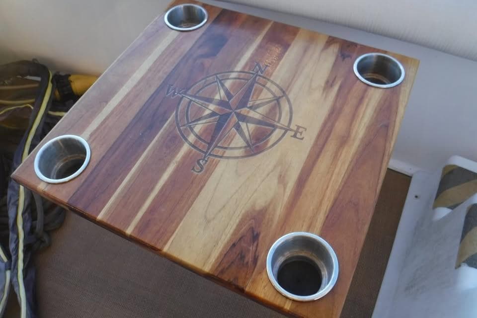 Wooden table with compass design and cup holders on a 1997 Sea Ray 400 Sedan Bridge.