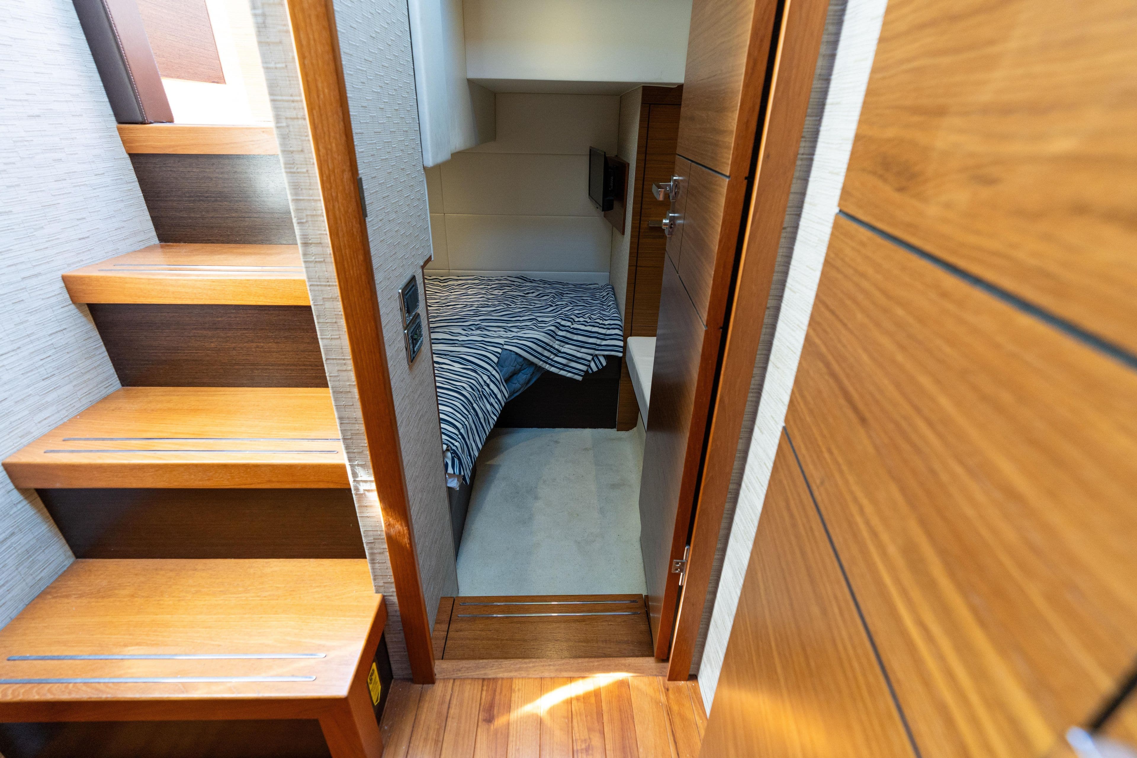 Interior of 2015 Tiara Yachts C44 Coupe, featuring wooden stairs and cozy cabin.