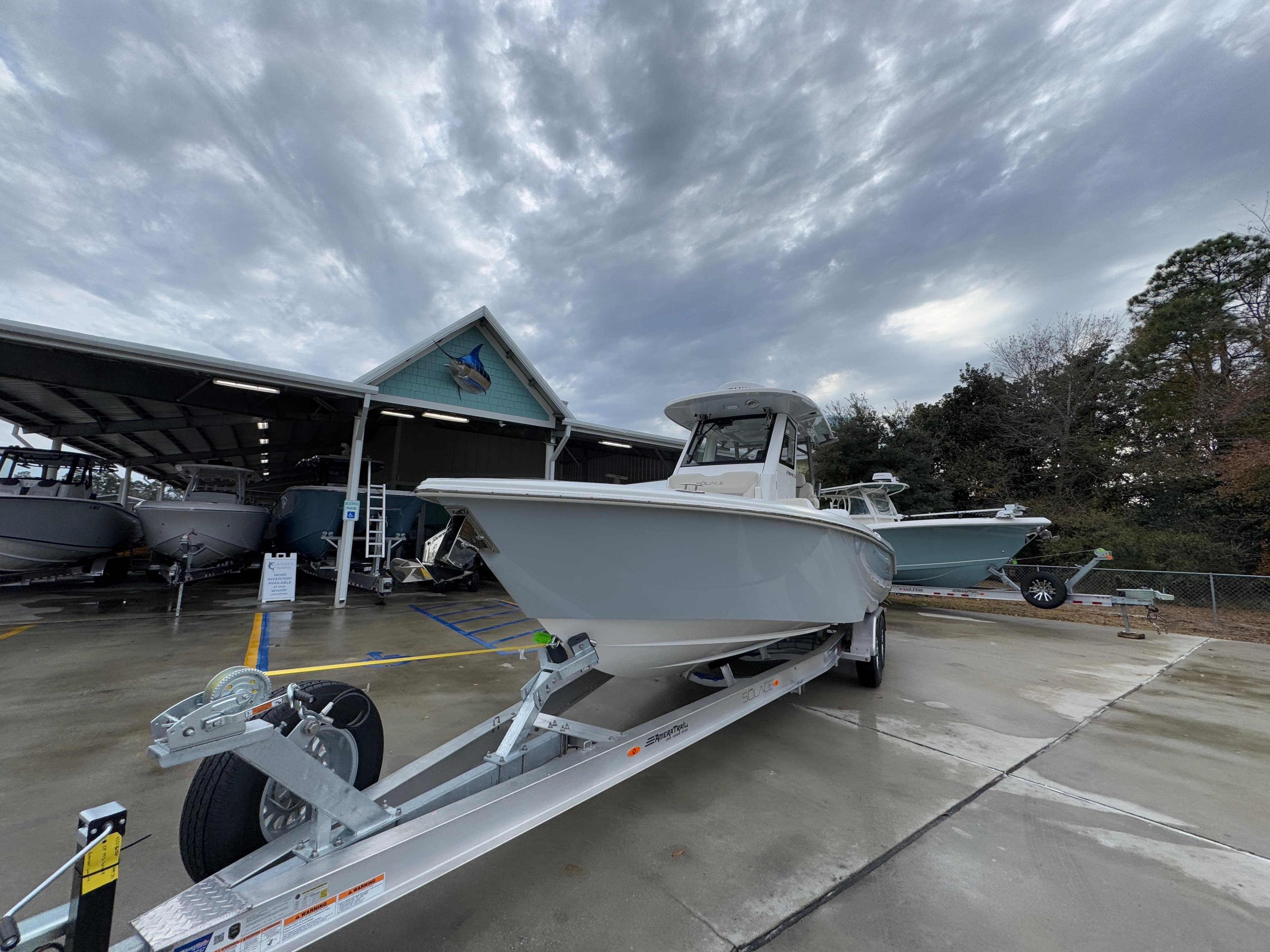 2025 Solace 28 HCS boat on trailer under cloudy sky at dealership.