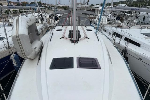 Sailing yacht Bavaria 46, 2018 model, docked with other boats in a marina.