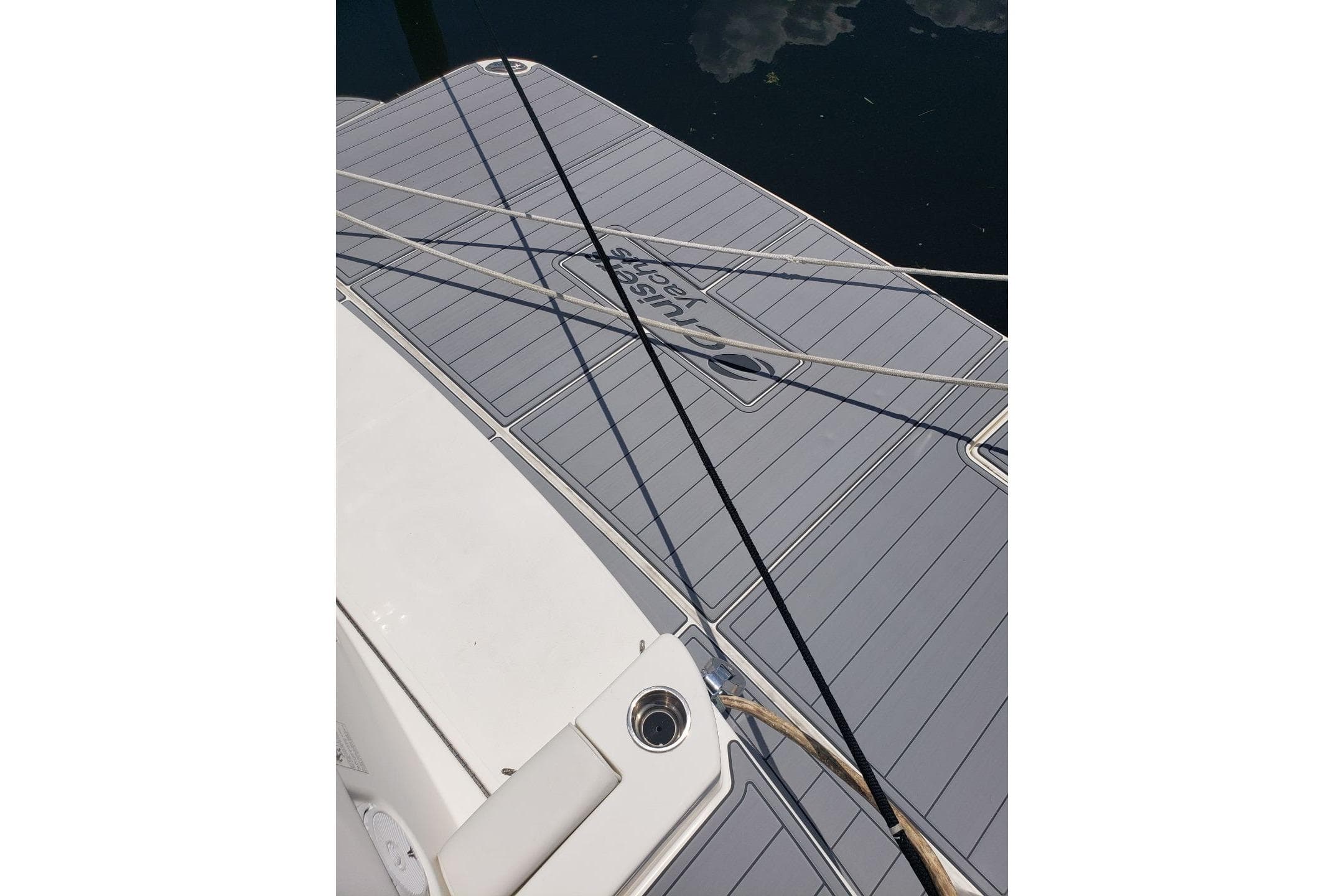 2006 Cruisers Yachts 520 Express swim platform with ropes and water reflection.