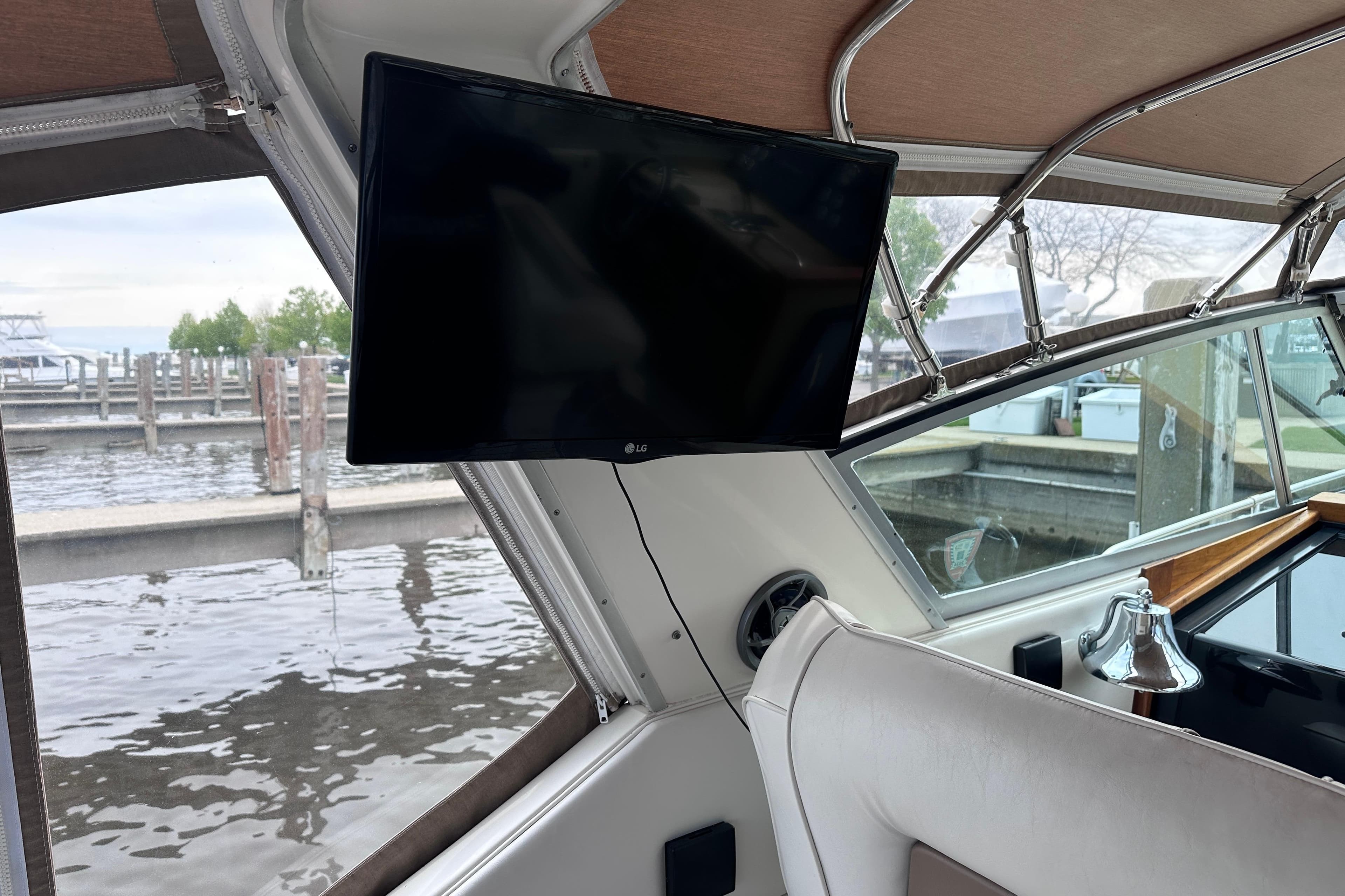 Interior of 1989 Sea Ray 390 Express Cruiser with mounted TV and marina view.