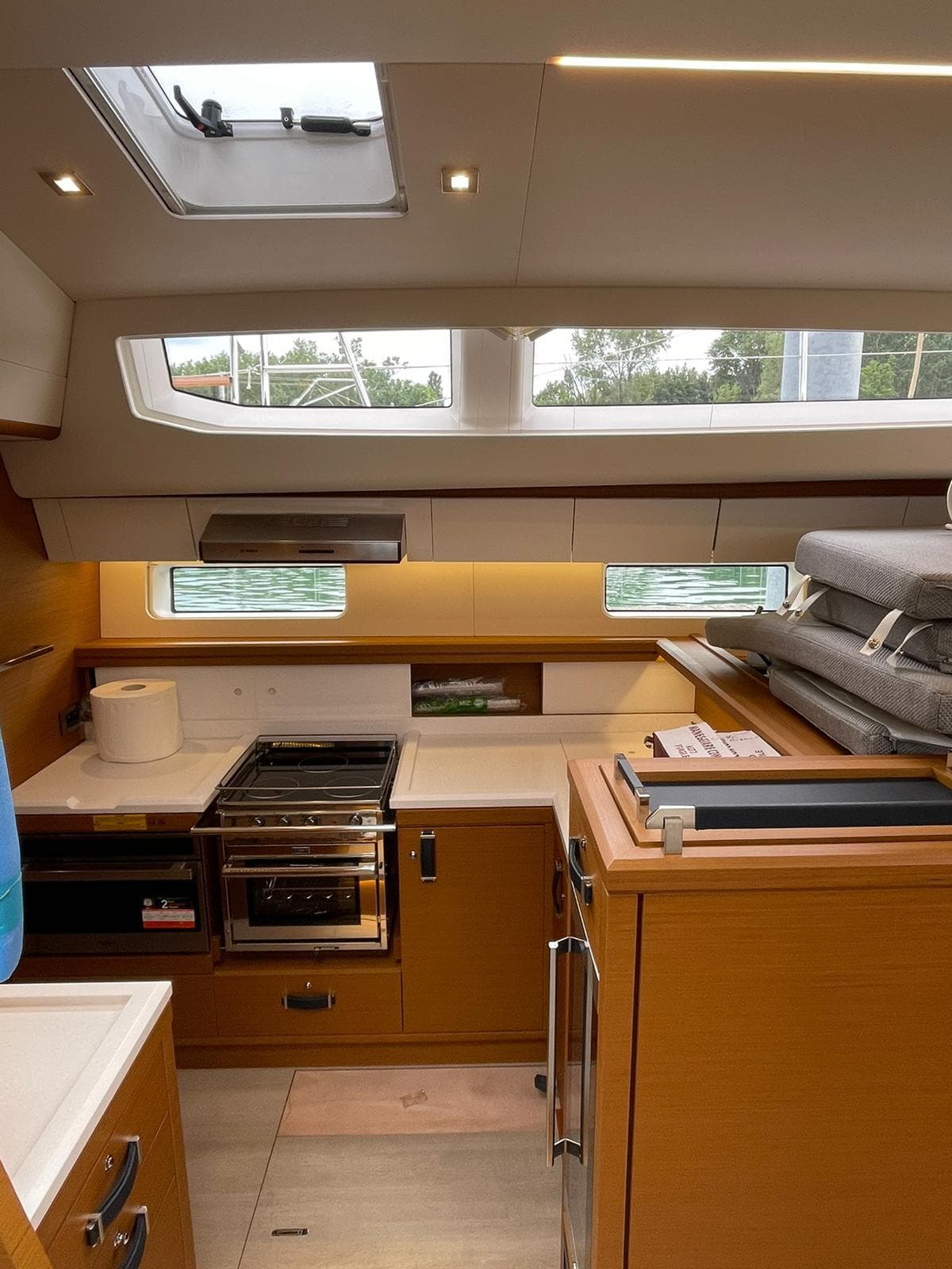 Interior of 2023 Jeanneau 65 yacht kitchen with modern appliances and natural light.