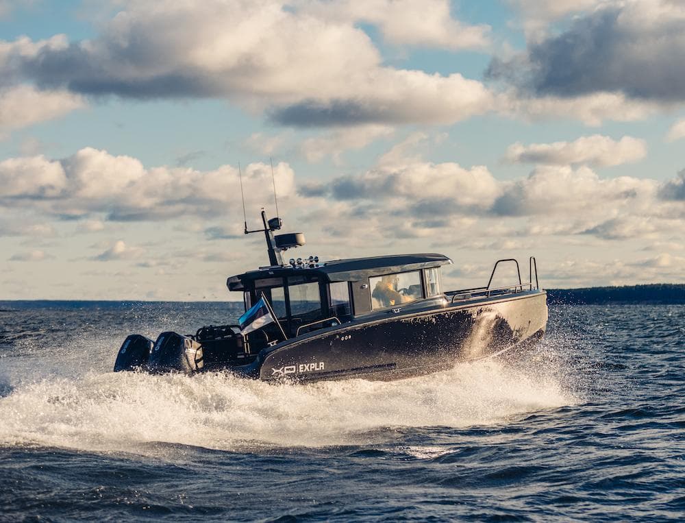 2024 XO Boats EXPLR 10S cruising on open water under a cloudy sky.