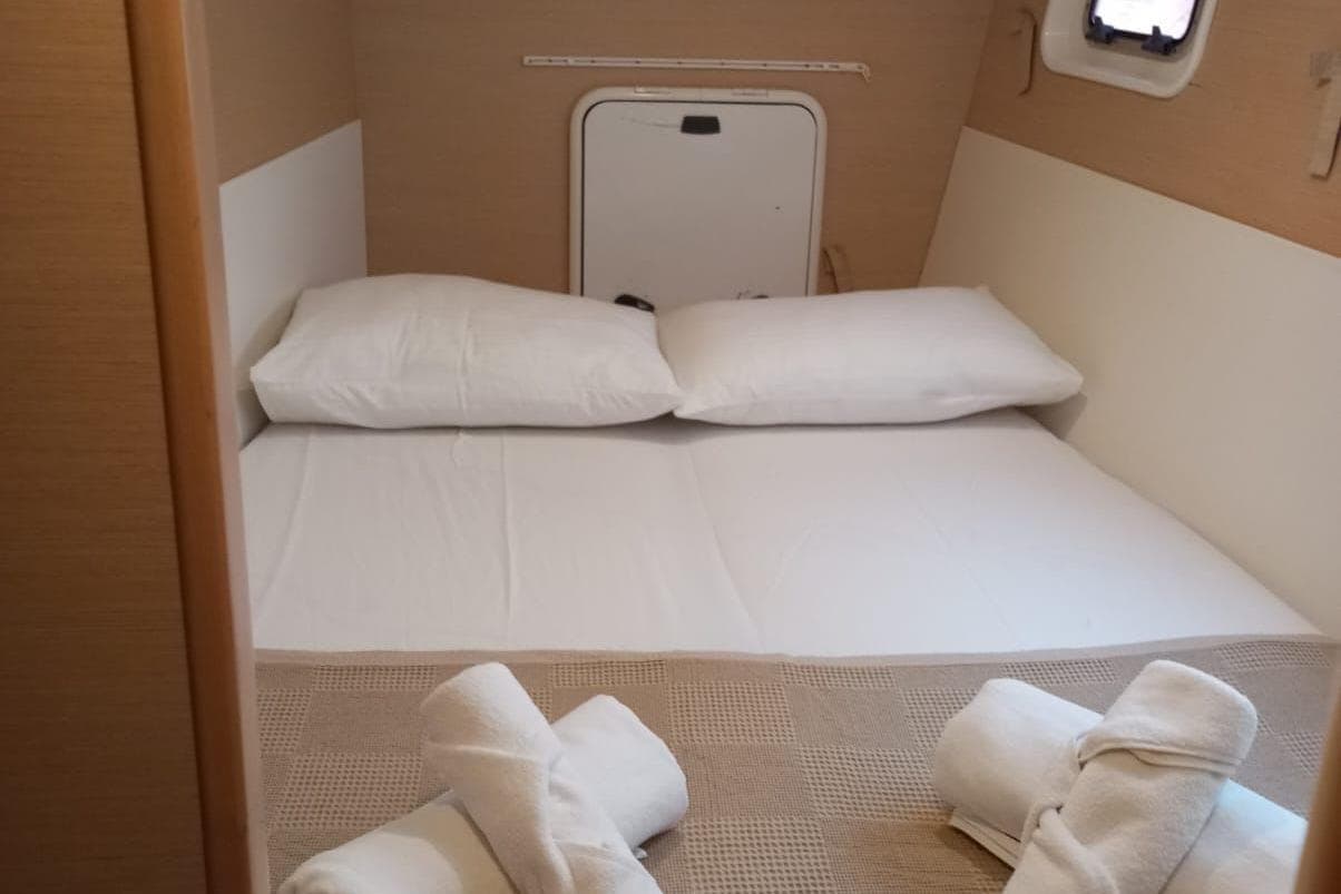 Cozy cabin interior of 2010 Lagoon 400 S2 catamaran with neatly arranged bedding.