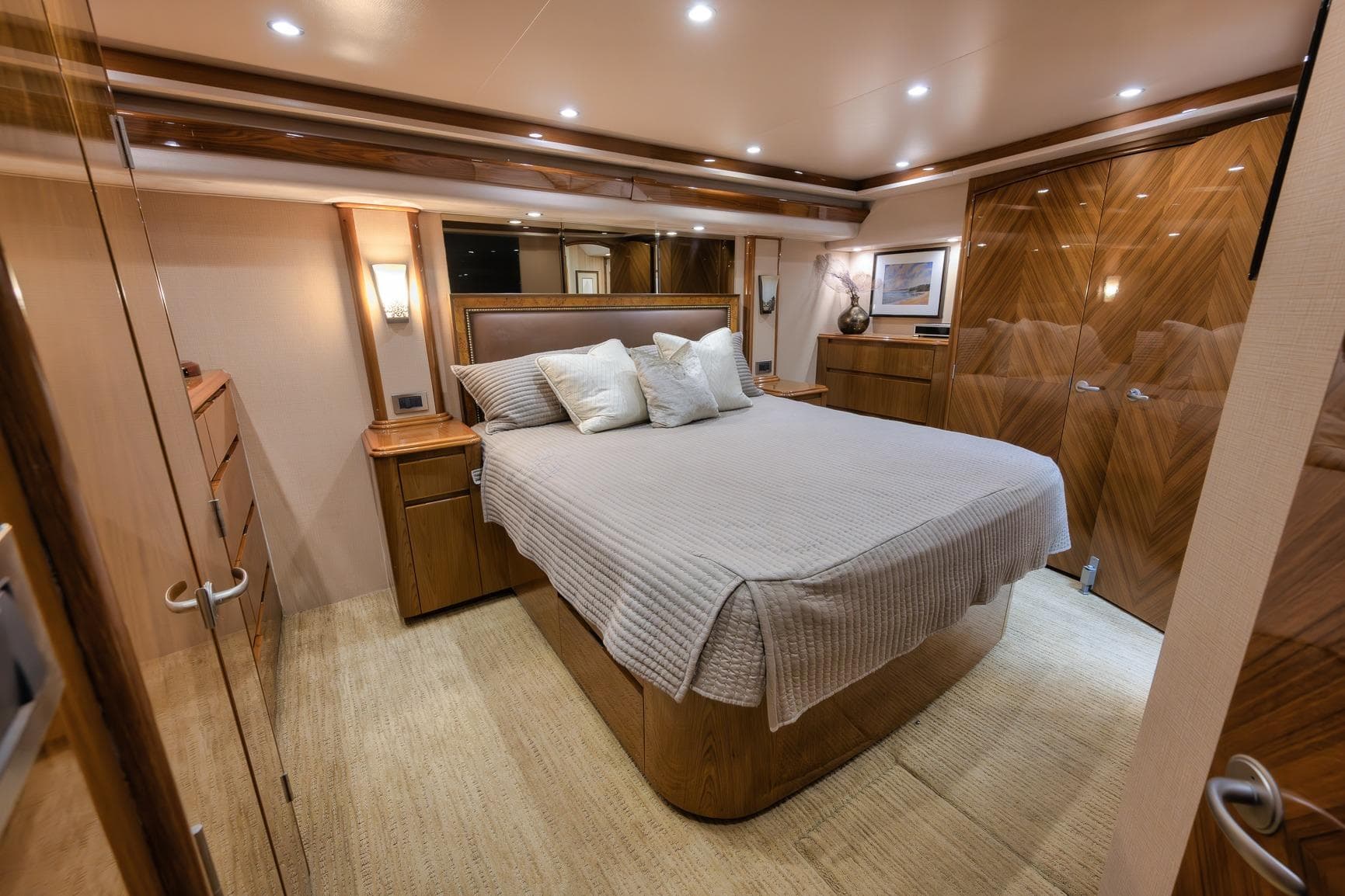 Luxurious bedroom interior of 2012 Viking 70 Enclosed Bridge yacht, featuring elegant wood finishes.