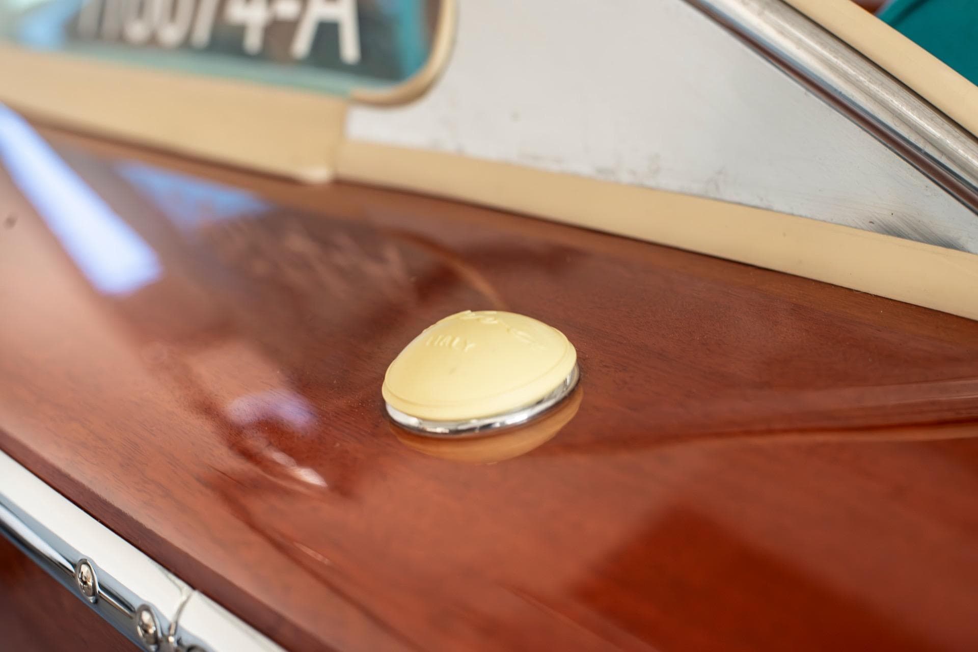 Close-up of a 1967 Riva Aquarama's polished wooden deck with a chrome detail.