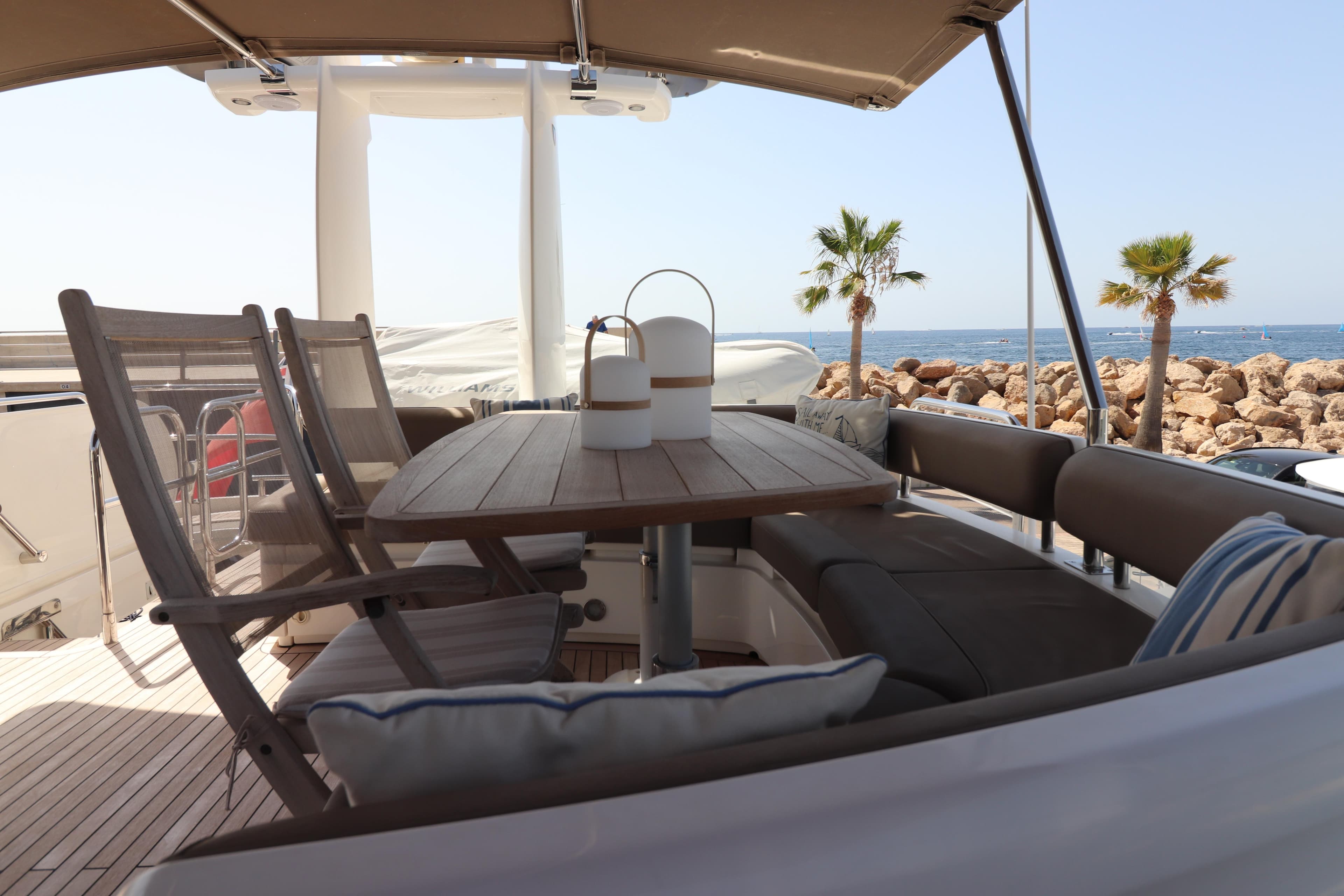 Luxurious 2007 Fairline Squadron 68 yacht deck with seating, table, and ocean view.