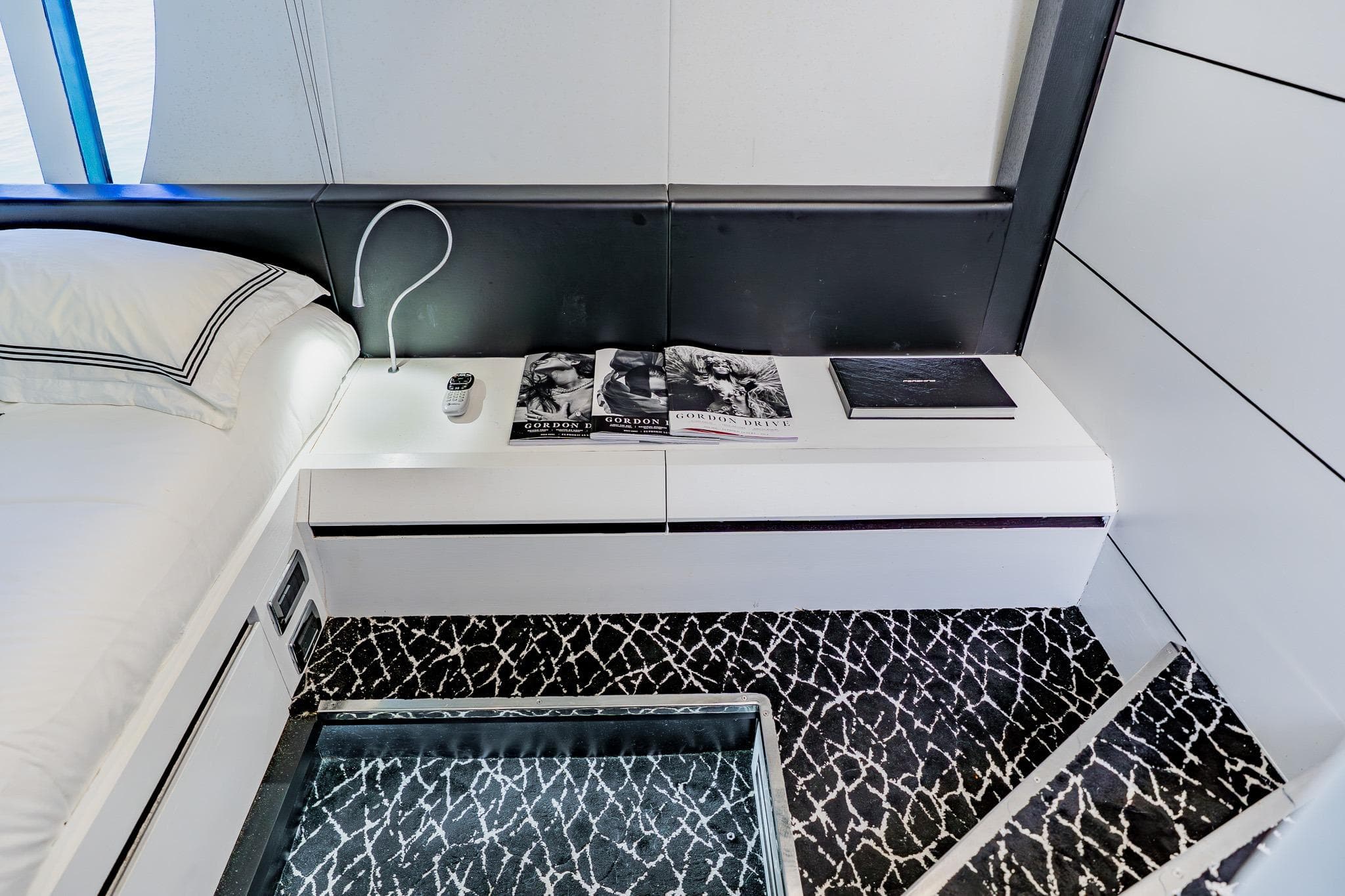 Luxurious interior of 2010 Pershing 80 yacht with modern bedside table and elegant decor.