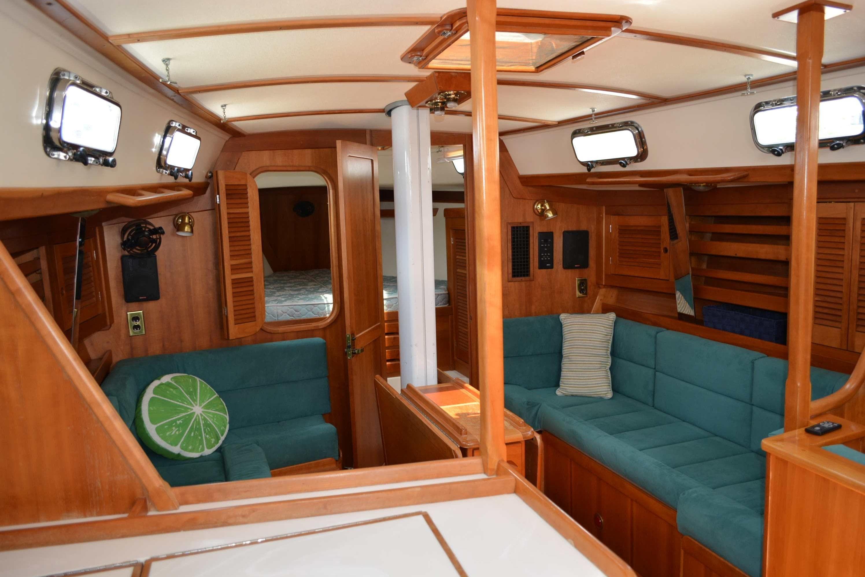 Interior of 1999 Tartan 4100 sailboat with teal seating and wooden finishes.