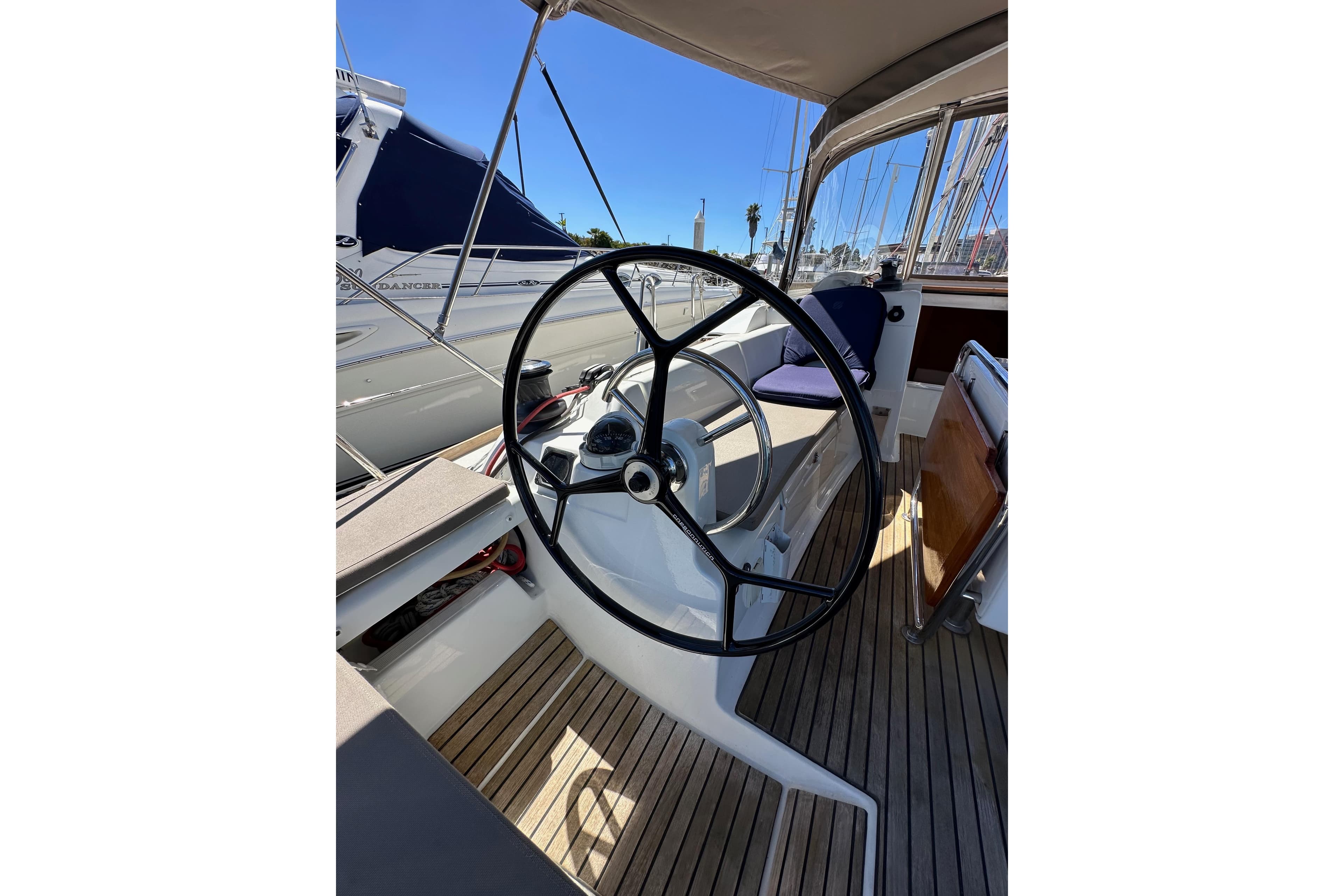 Steering wheel of 2015 Jeanneau Sun Odyssey 409 sailboat, docked in marina.