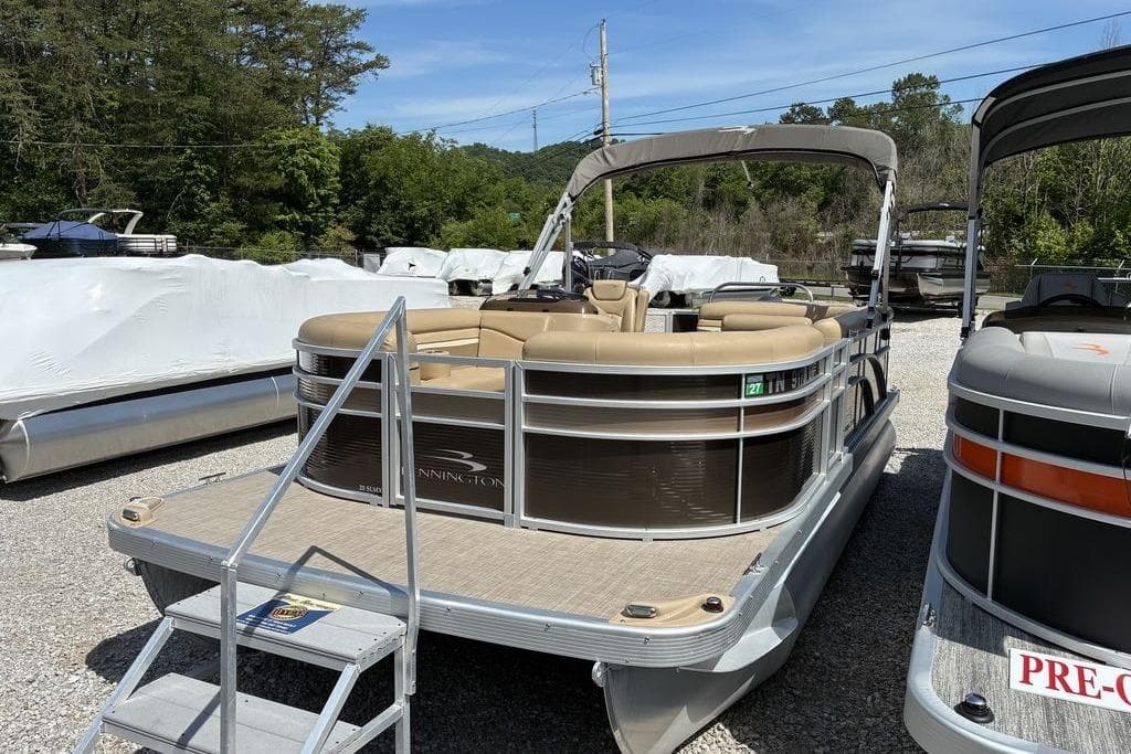 2017 Bennington 20SLMX pontoon boat with beige seating, parked outdoors.