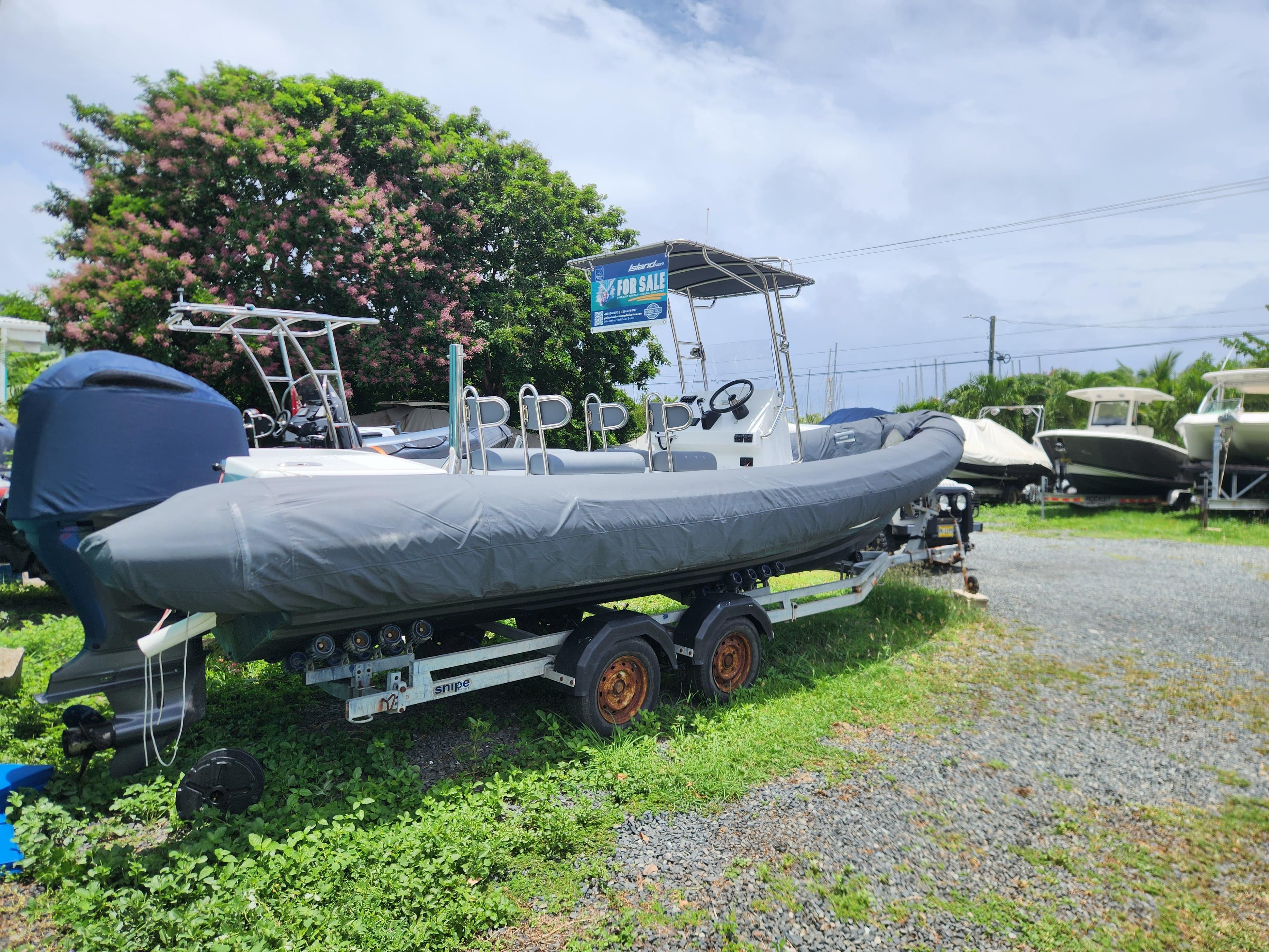 2023 Island RIBs 7.5 m boat on trailer, covered, in outdoor setting.