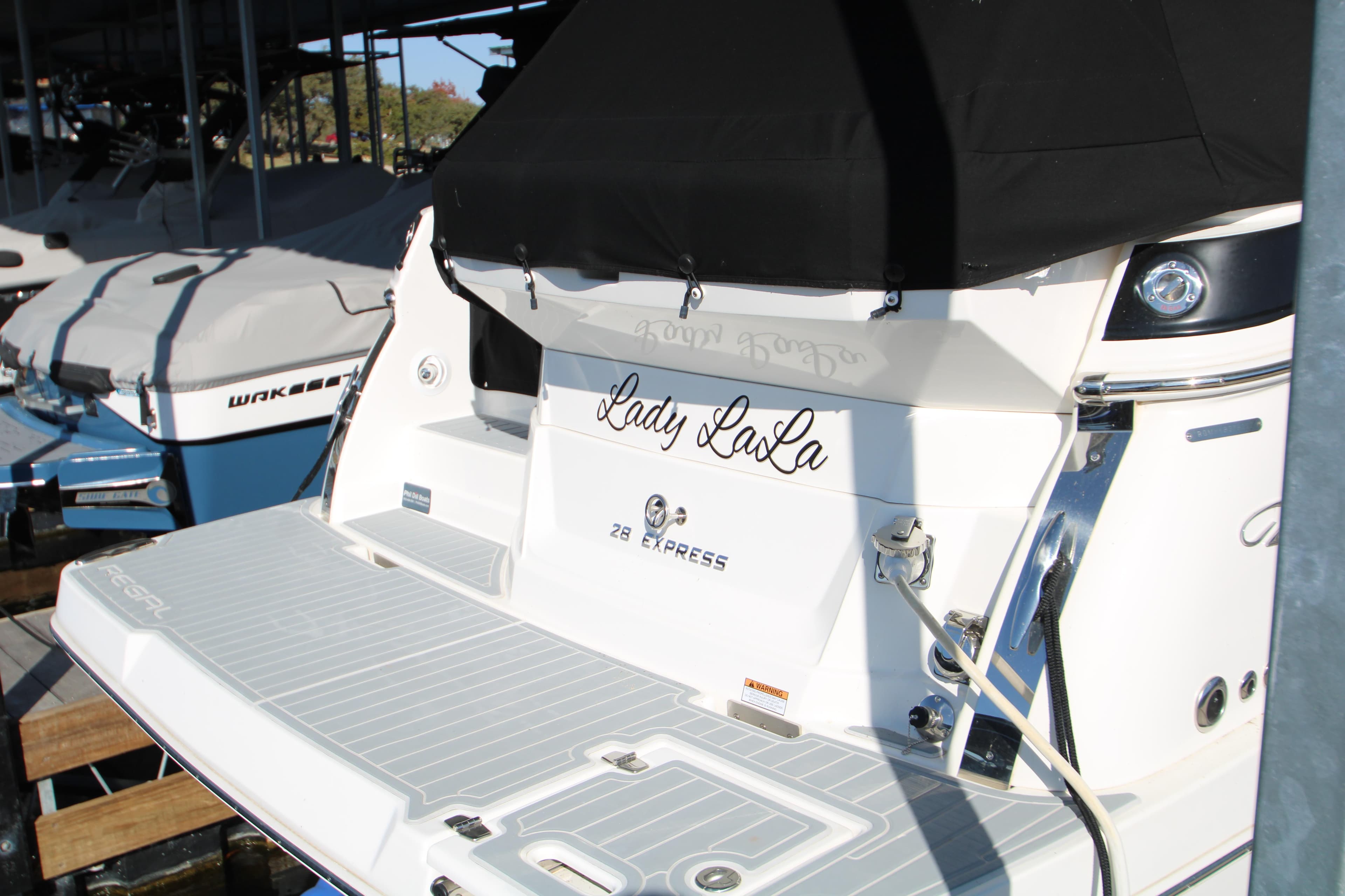 2022 Regal 28 Express boat named "Lady LaLa" docked in marina.