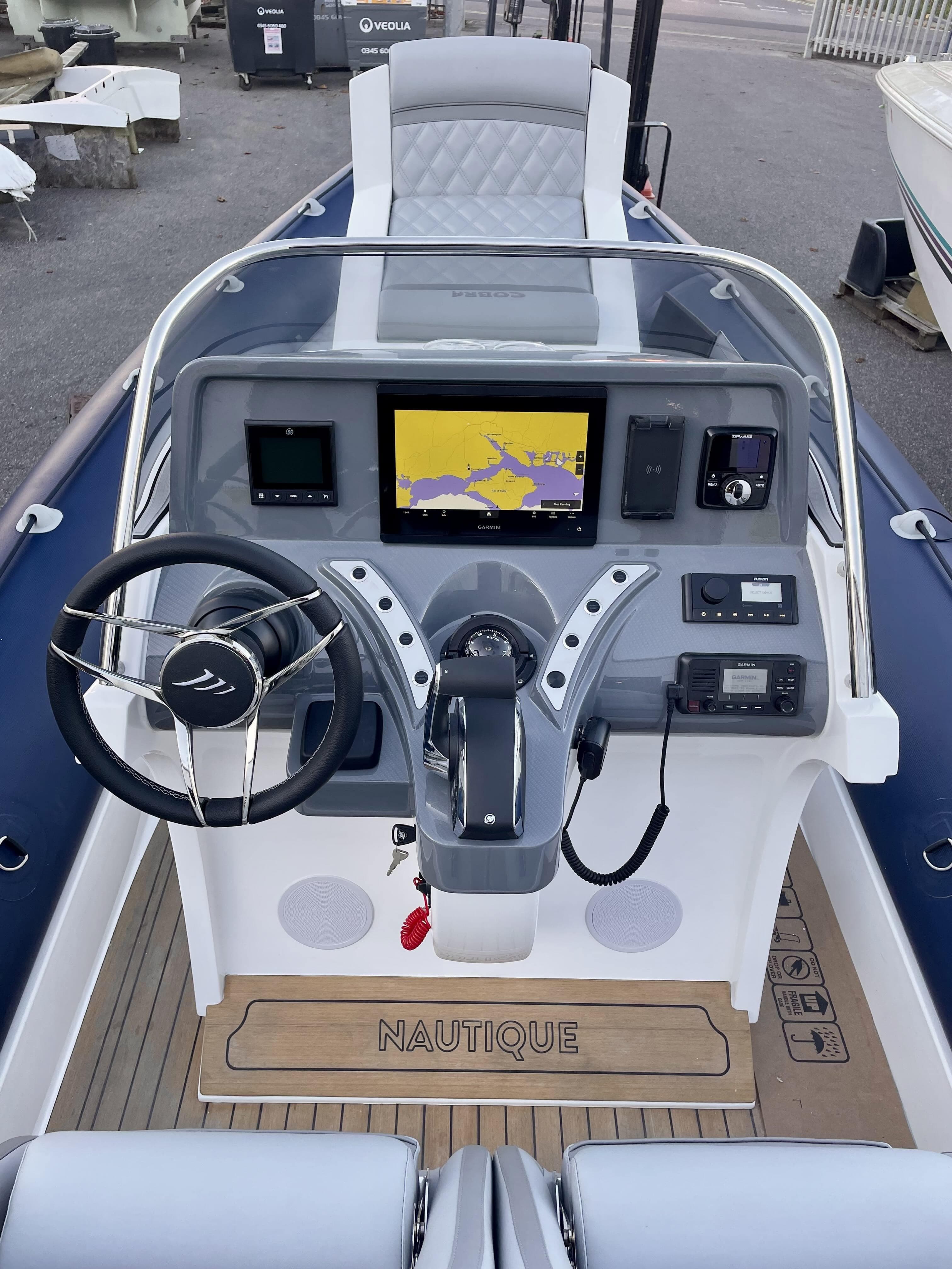 2024 Cobra Ribs Nautique 8.2m boat dashboard with steering wheel and navigation display.