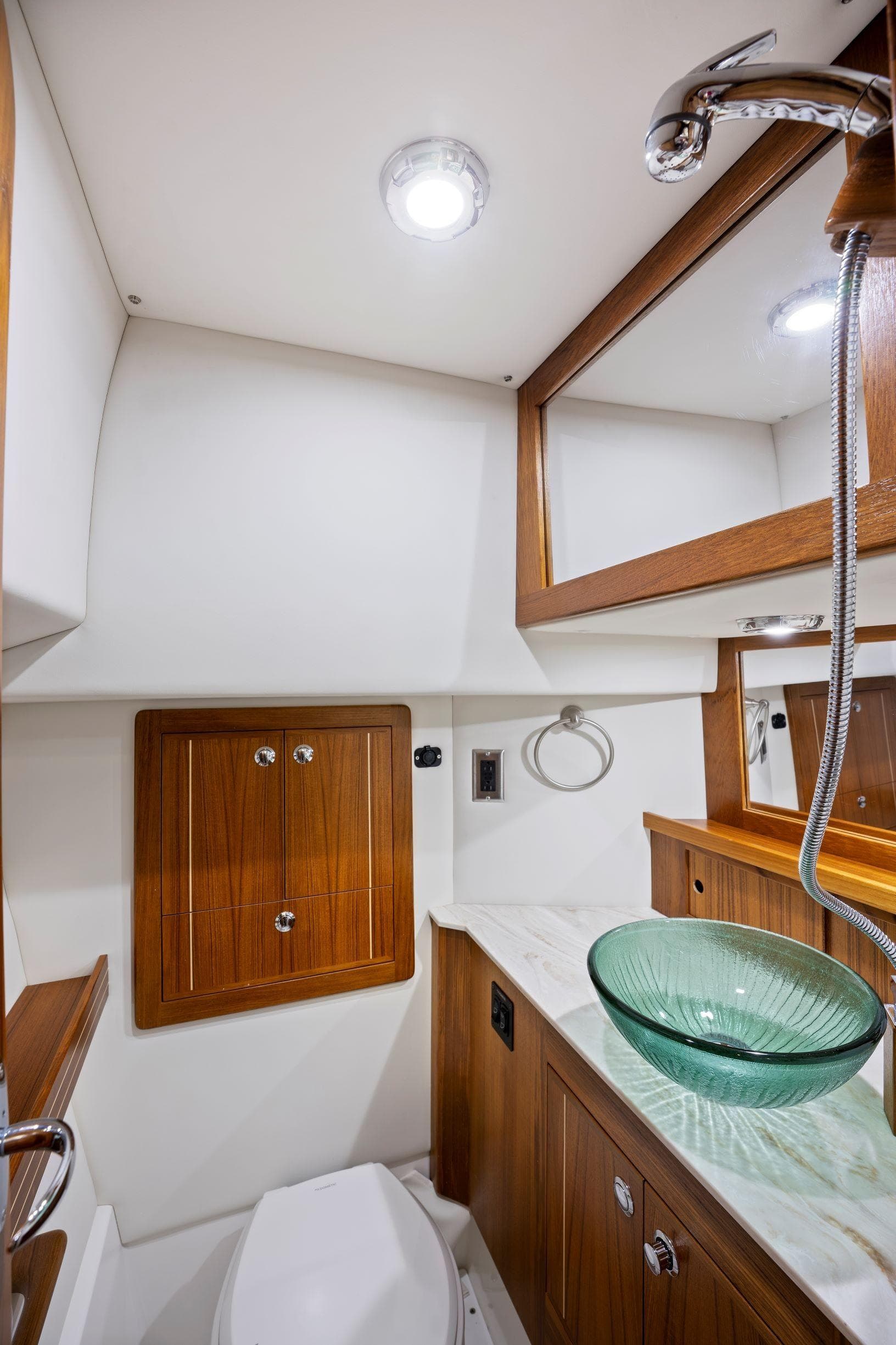 Modern yacht bathroom with wooden accents, glass sink, and sleek fixtures in Aspen C100, 2026 model.