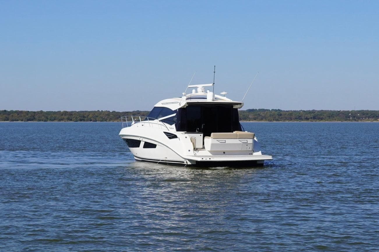 2015 Sea Ray 470 Sundancer yacht cruising on a calm lake under clear blue skies.