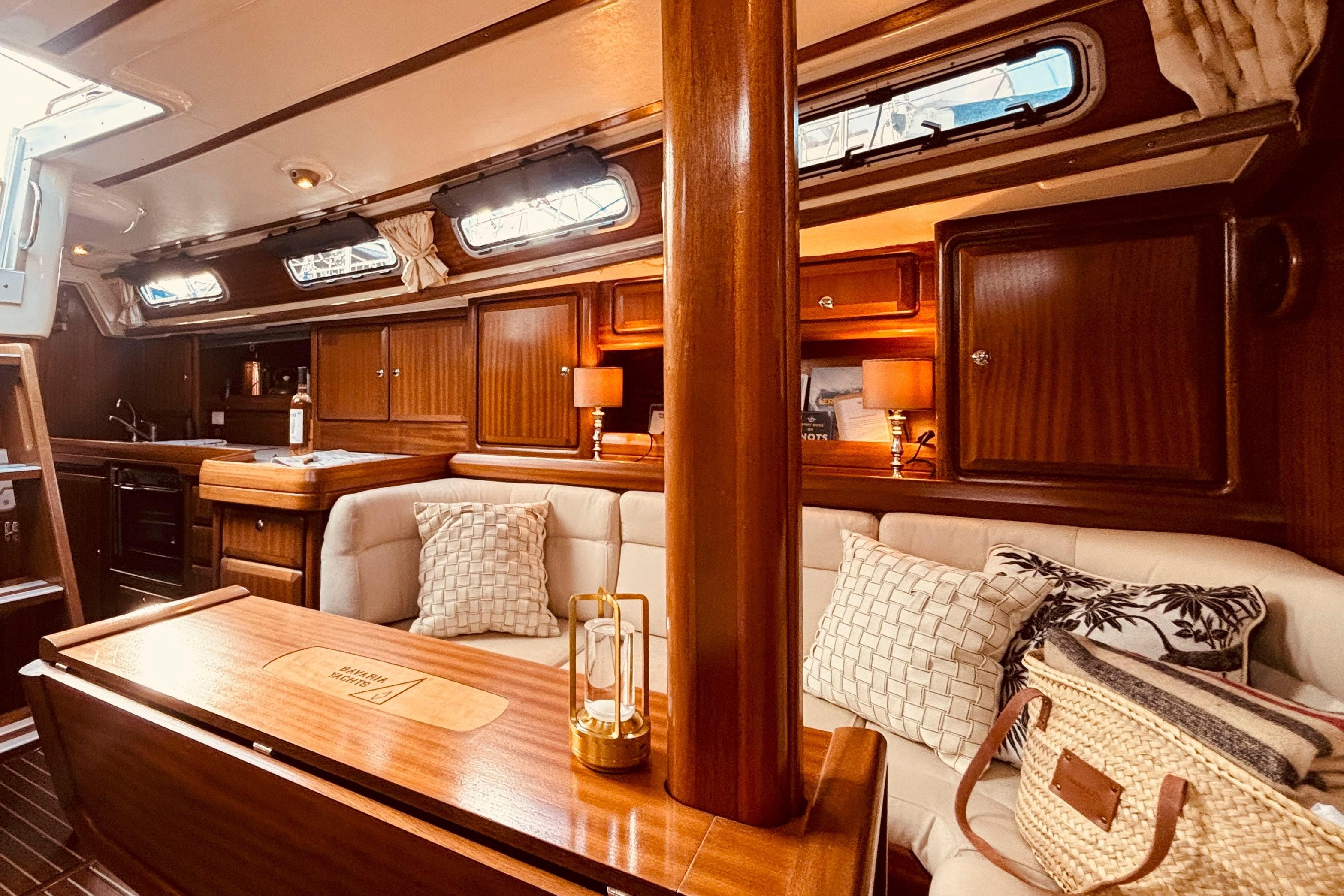 Luxurious interior of 1999 Bavaria 38 Ocean yacht with elegant wood finish and cozy seating.