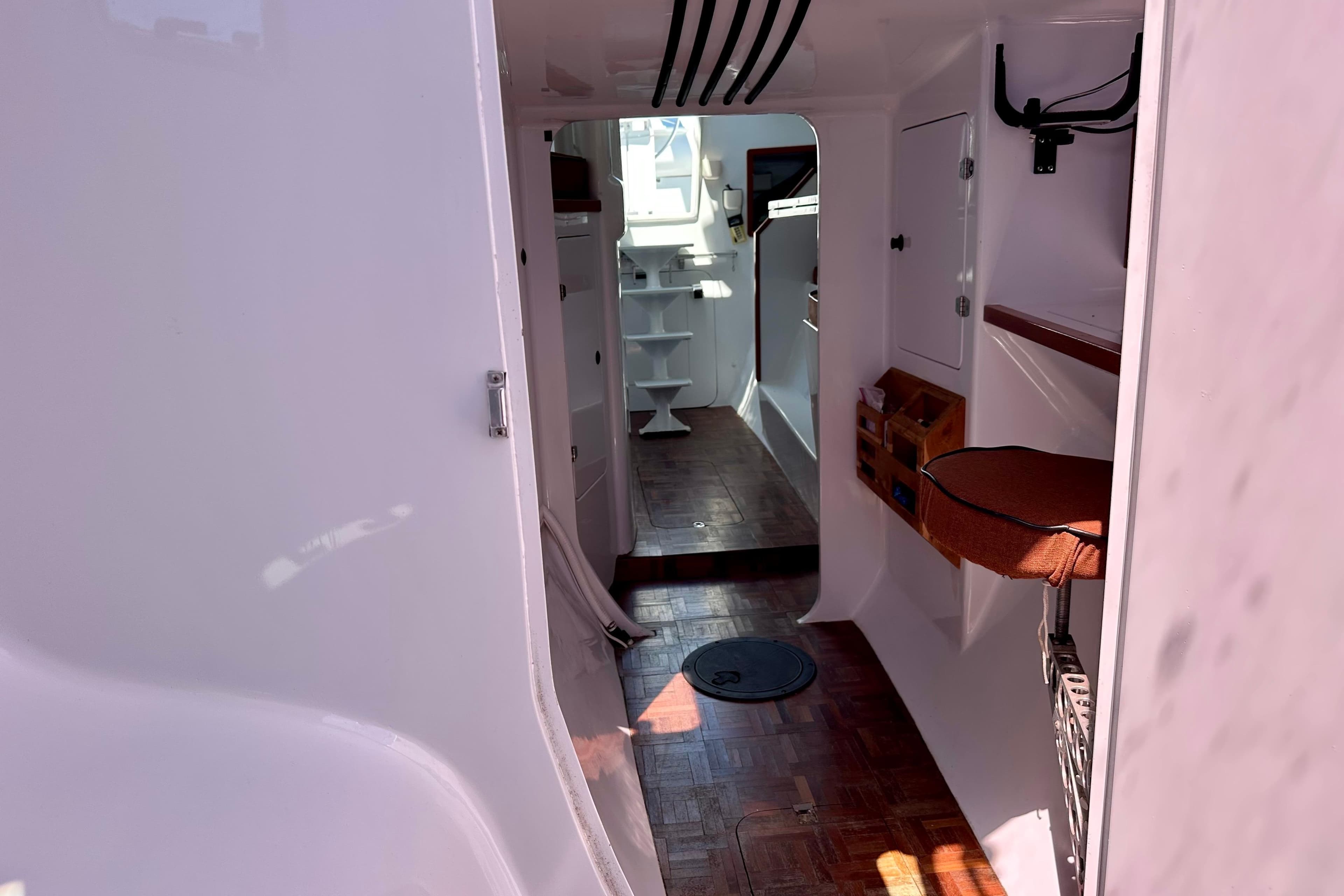 Interior view of a 2012 Hughes 40 boat, featuring white walls and wooden flooring.