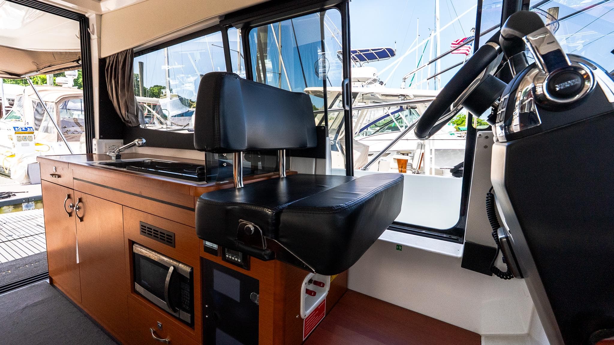 Interior of 2018 Jeanneau NC11 boat with helm and kitchenette area.