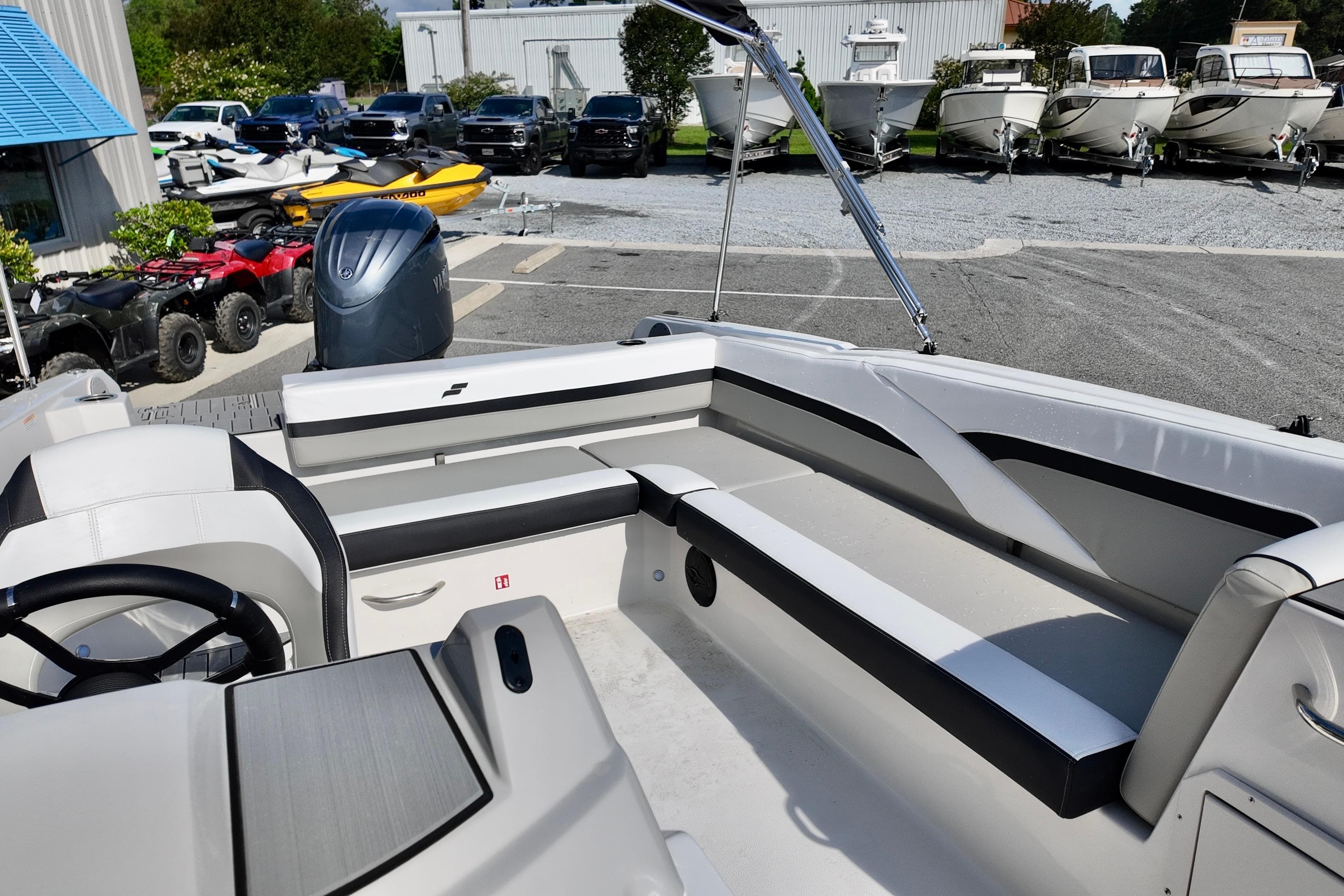 2026 Starcraft SVX 211 OB boat interior with seating and steering wheel, parked outdoors.