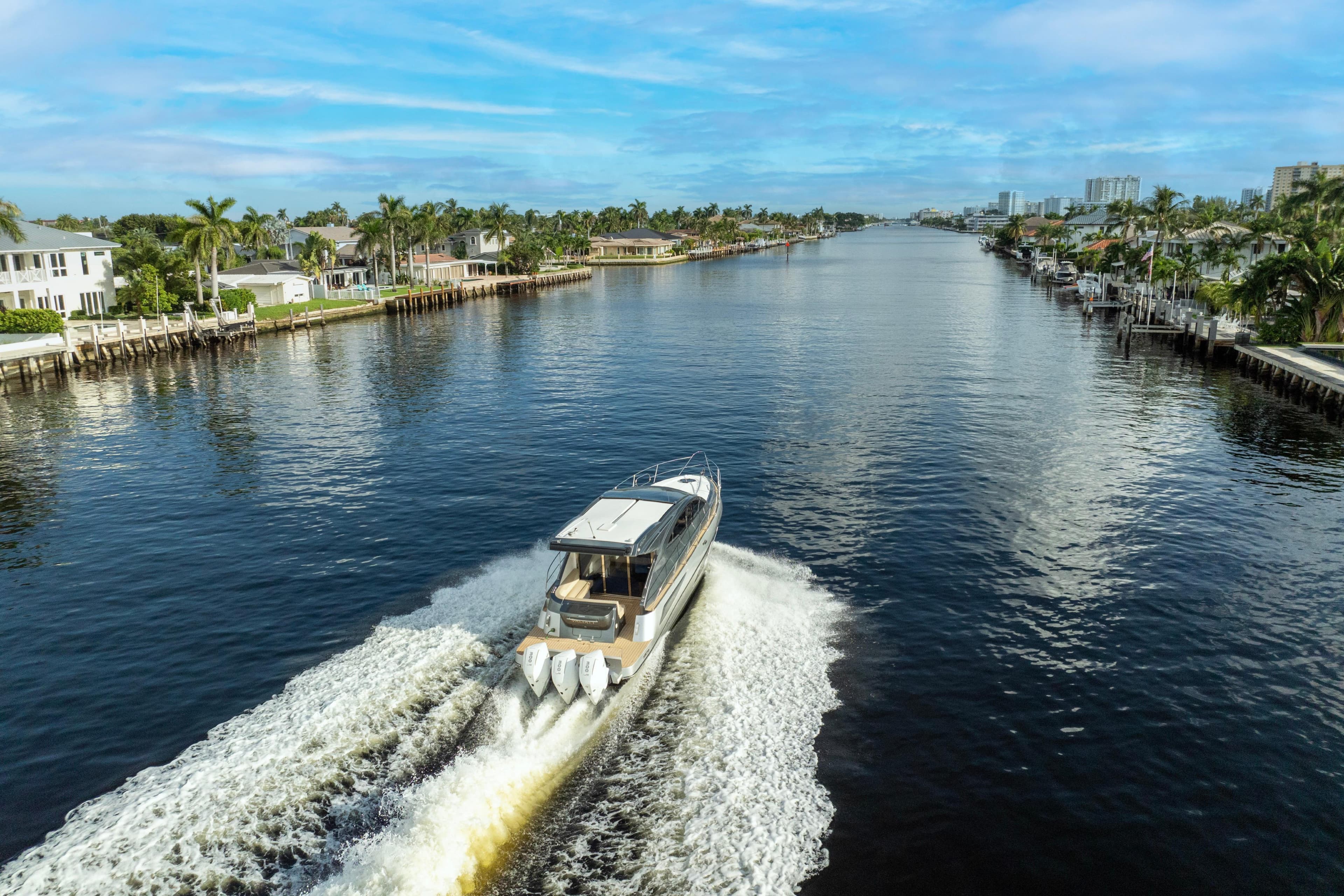 Valiatt 410HT 2025 cruising on a scenic waterway with palm trees and blue sky.