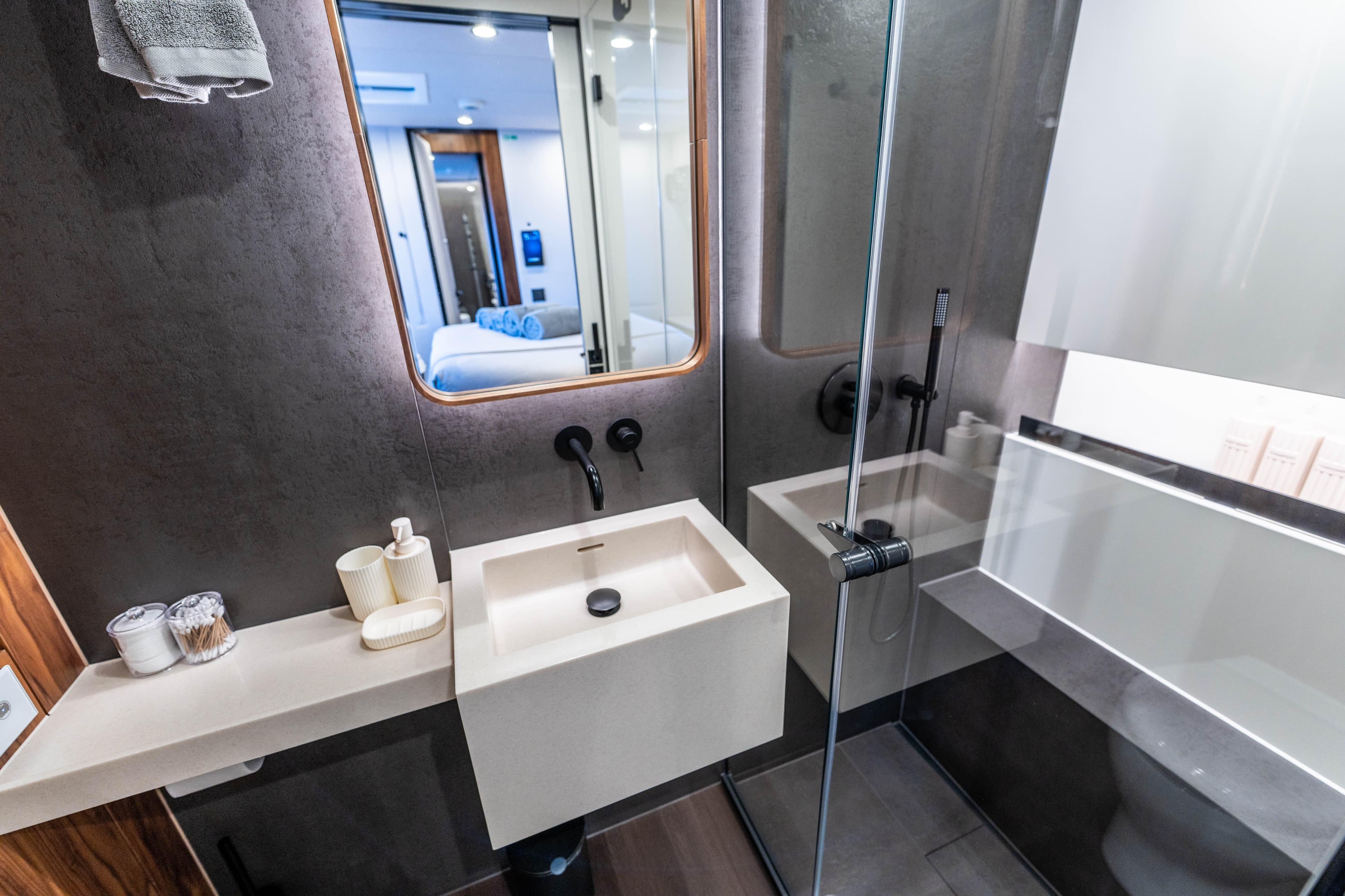 Luxurious bathroom interior on 2025 Sunreef 60 yacht, featuring modern sink and glass shower.