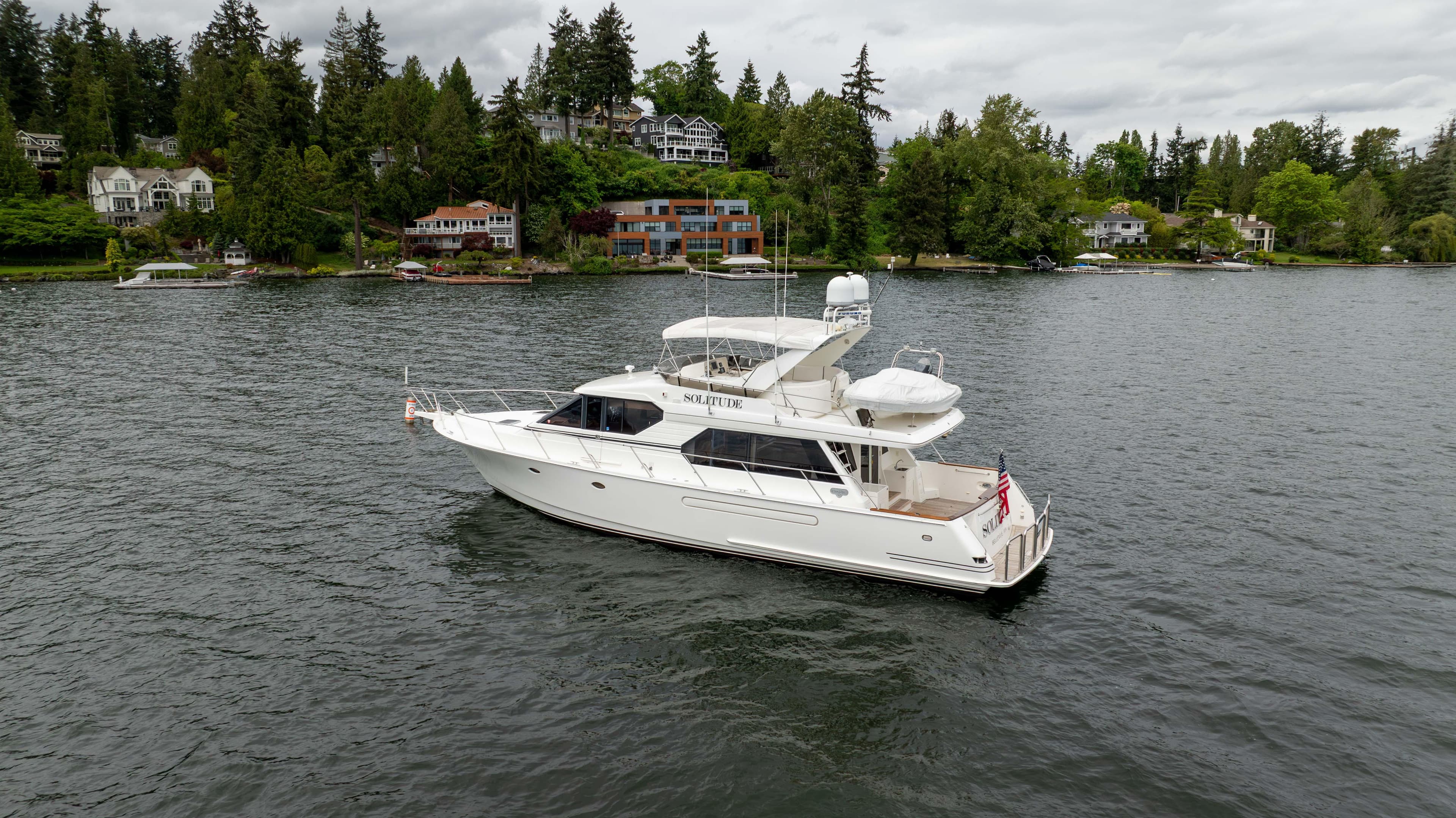 2001 West Bay 58 RPH yacht on a scenic lake with lush greenery.