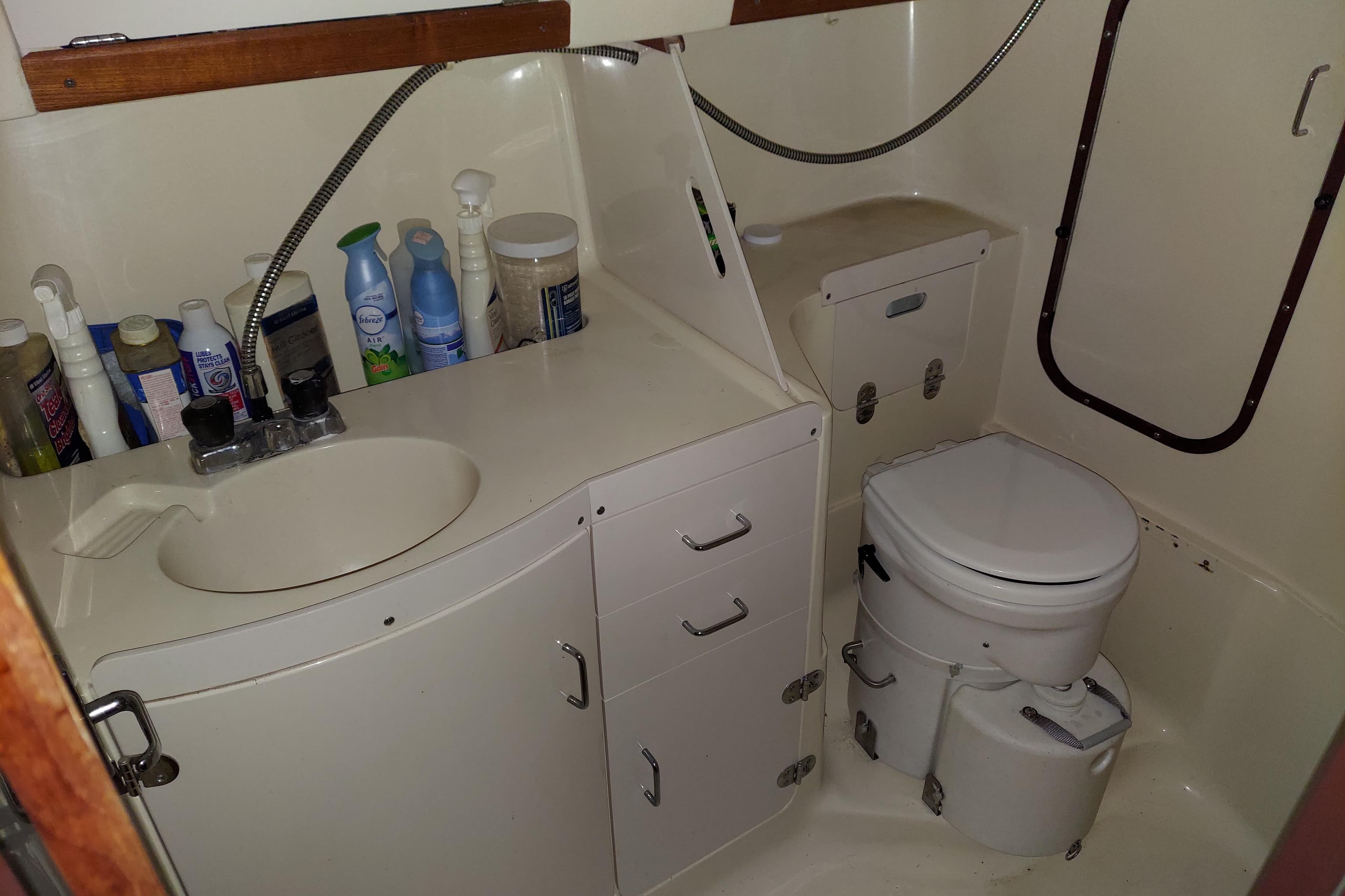 Bathroom of a 1997 Hunter 336 sailboat with sink, toilet, and storage.