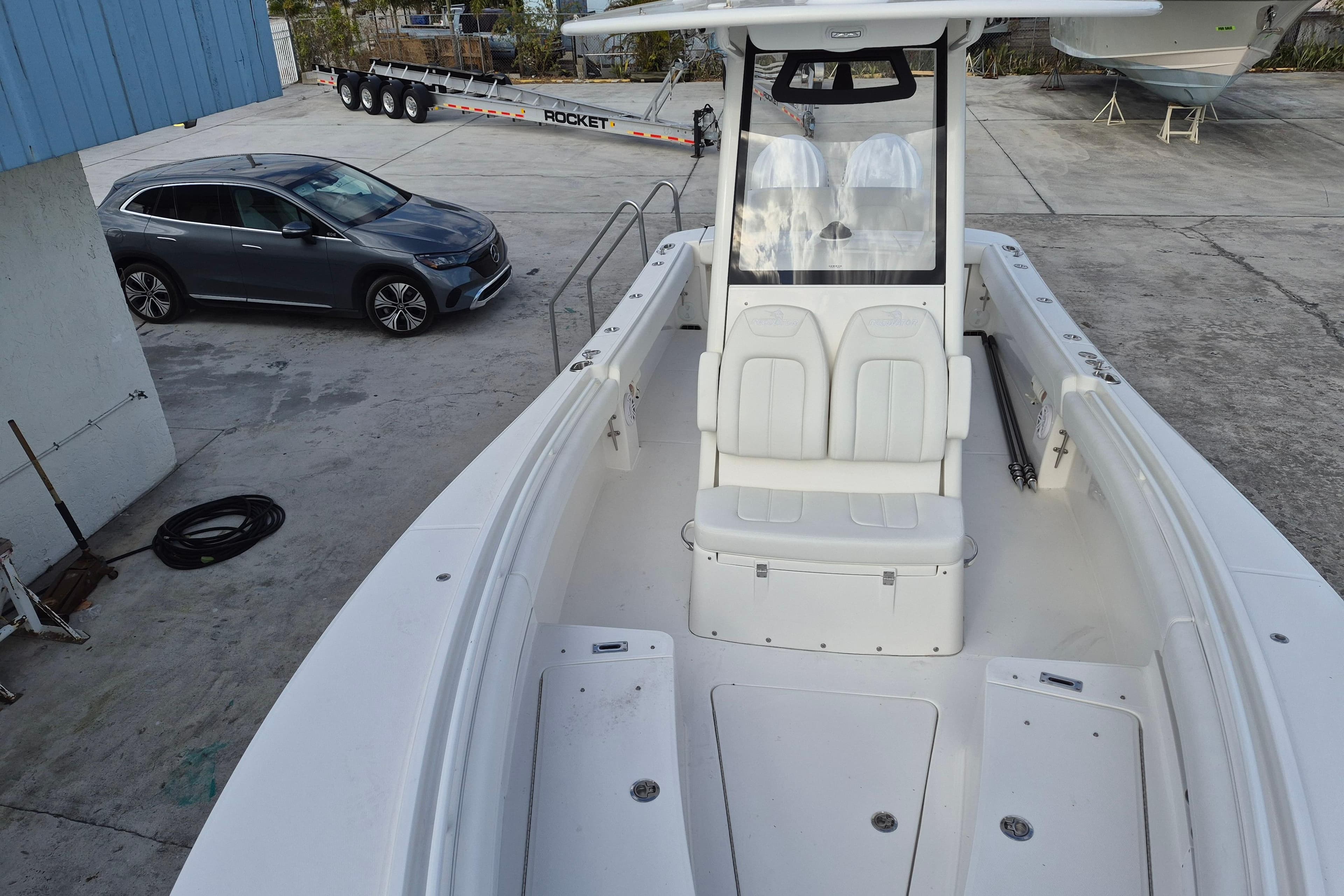 2026 Regulator 25 boat in a marina with a nearby parked car.